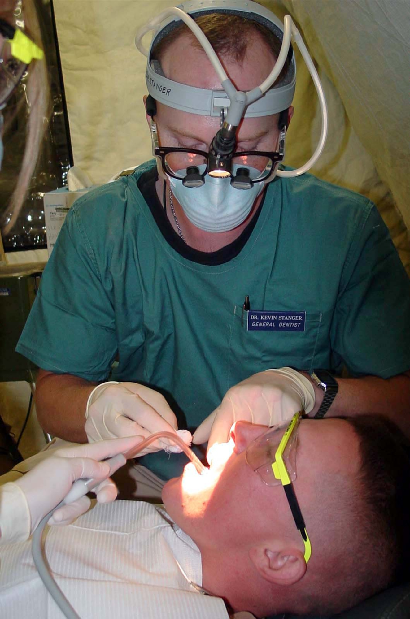 OPERATION IRAQI FREEDOM -- Maj. (Dr.) Kevin Stanger takes care of a filling for Army Spc. Jason Ramer of the 1st Batallion, 293th Infantry Regiment.  As the only military dentist for hundreds of square miles, Stanger provides care for coalition forces from the United States, United Kingdom, Poland, Italy and South Korea.  He is assigned to the 407th Expeditionary Medical Squadron at Tallil Air Base in southern Iraq.  (U.S. Air Force photo by Maj. Jon Anderson)