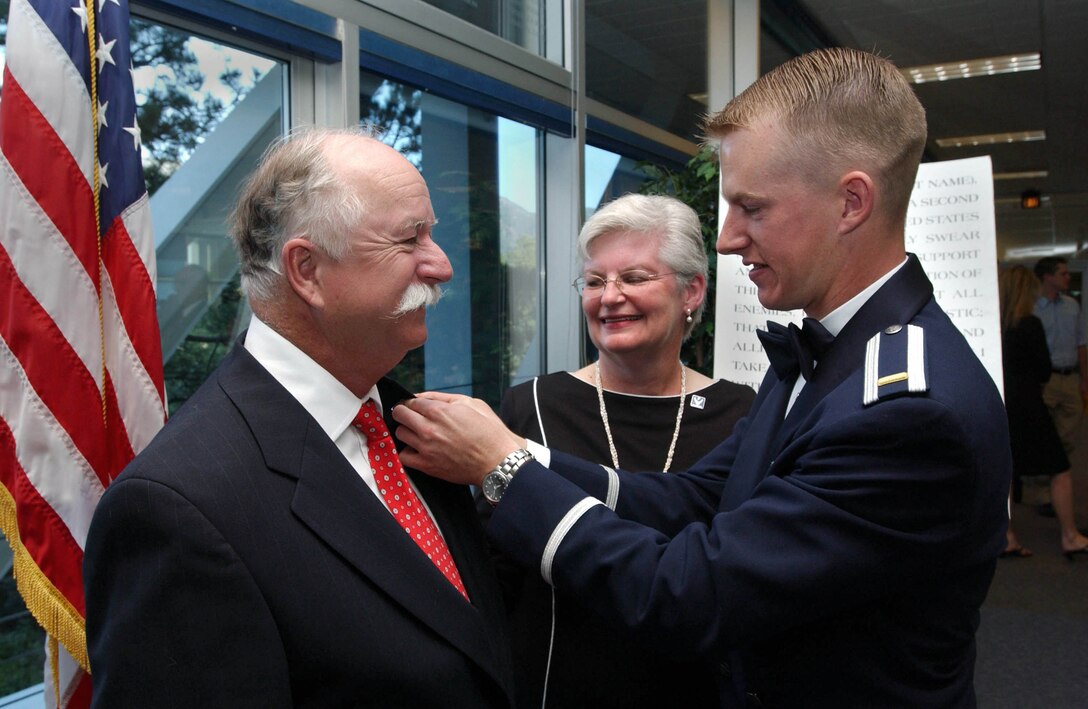 U.S AIR FORCE ACADEMY, Colo. -- Newly commissioned 2nd Lt. Randy Kinsey presents the Air Force Parent Pin to his parents, Cliff and Jill Kinsey of North Richland Hills, Texas.  The pin was established by the Air Force to thank the parents of America's airmen for their support of their children's service.  The lieutenant is one of 998 officers who were commissioned here May 28.  (U.S. Air Force photo by Ken Wright)