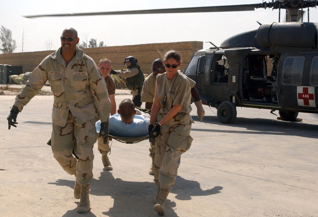 OPERATION IRAQI FREEDOM -- Senior Master Sgt. Ken Quattlebaum (left) and 2nd Lt. Beverly Groogand (right) carry a wounded soldier from a helicopter to an ambulance en route to the mobile aeromedical staging facility.  The 379th Expeditionary Aeromedical Evacuation Squadron at Baghdad International Airport comprises members of the Tennessee Air National Guard's 118th Aeromedical Evacuation Squadron in Nashville.  (U.S. Air Force photo by Tech. Sgt. Ruby Zarzyczny)