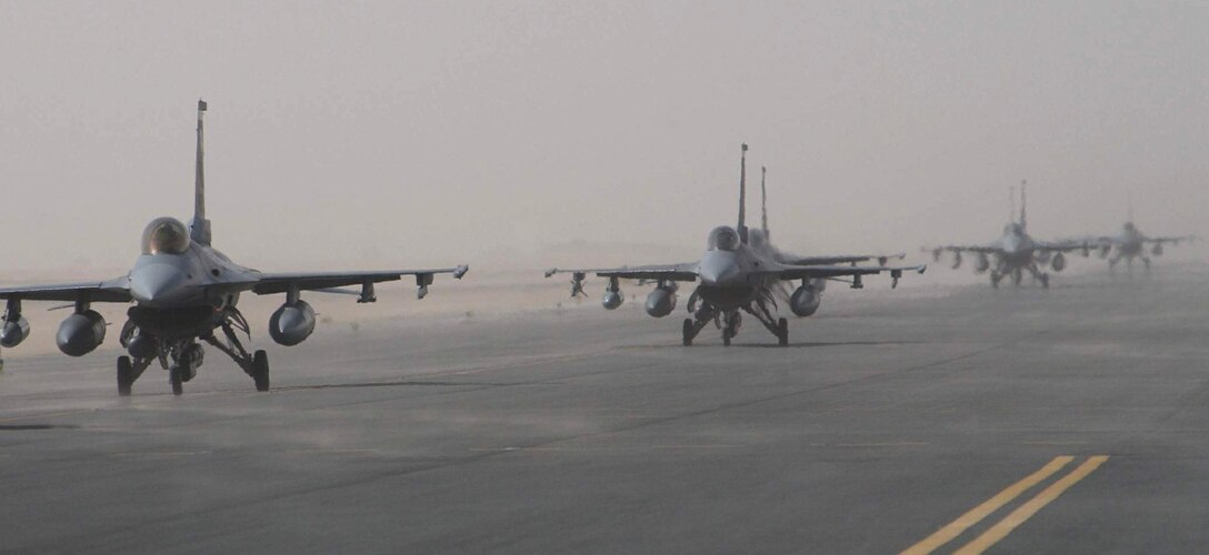 OPERATION IRAQI FREEDOM -- F-16 Fighting Falcons taxi toward parking spots at a forward-deployed location in Southwest Asia.  Airmen and aircraft from Hill Air Force Base, Utah, are currently deployed supporting Operation Iraqi Freedom.  (U.S. Air Force photo by Master Sgt. Terry L. Blevins)