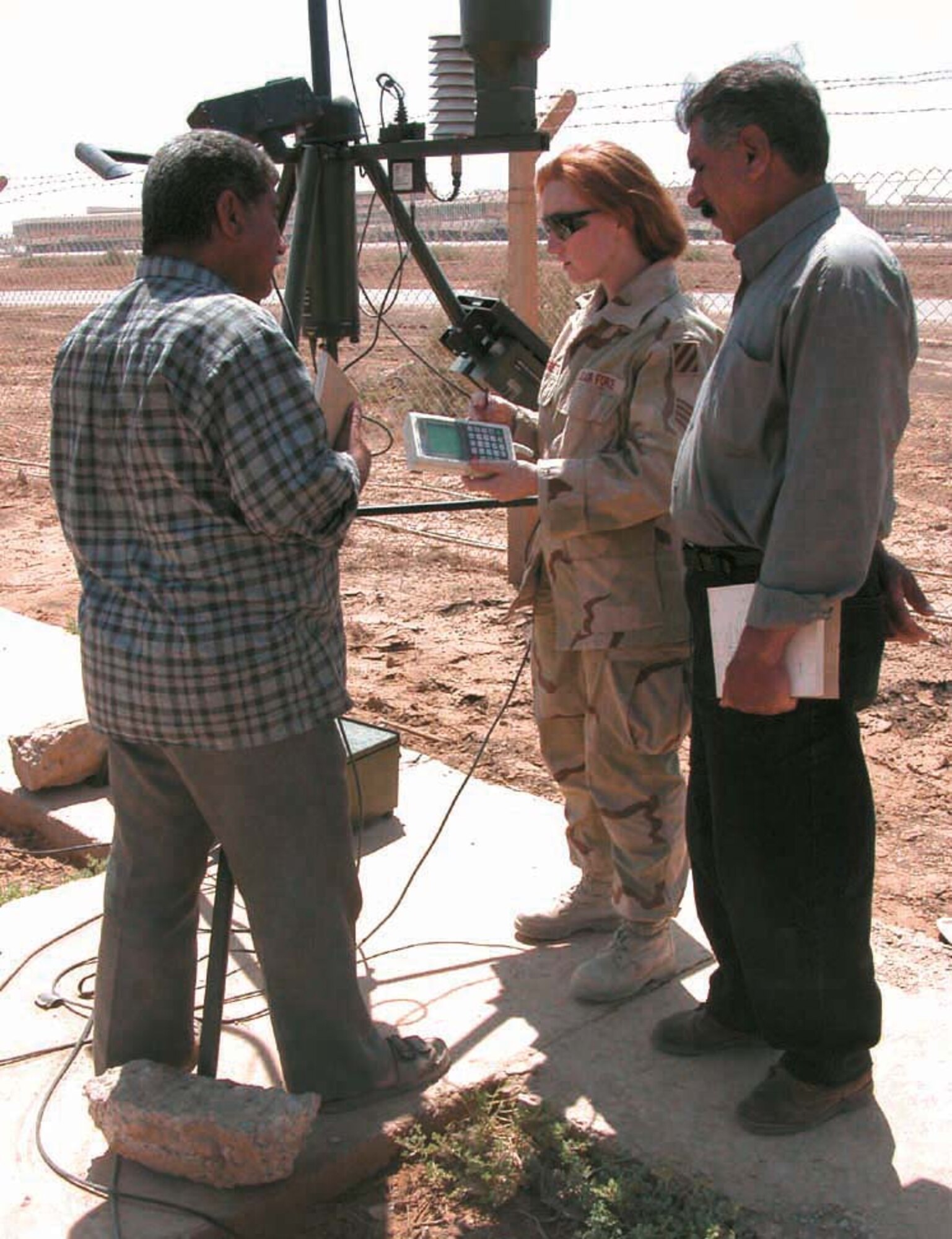 OPERATION IRAQI FREEDOM -- Staff Sgt. Julie Moretto show two members of Iraq's meteorological organization how to detect thunderstorms and lightning.  Moretto is a 447th Air Expeditionary Group airman deployed to Baghdad from the 15th Air Support Operations Squadron at Hunter Army Air Field, Ga.  (U.S. Air Force photo by 2nd Lt. Rebecca R. Garland)