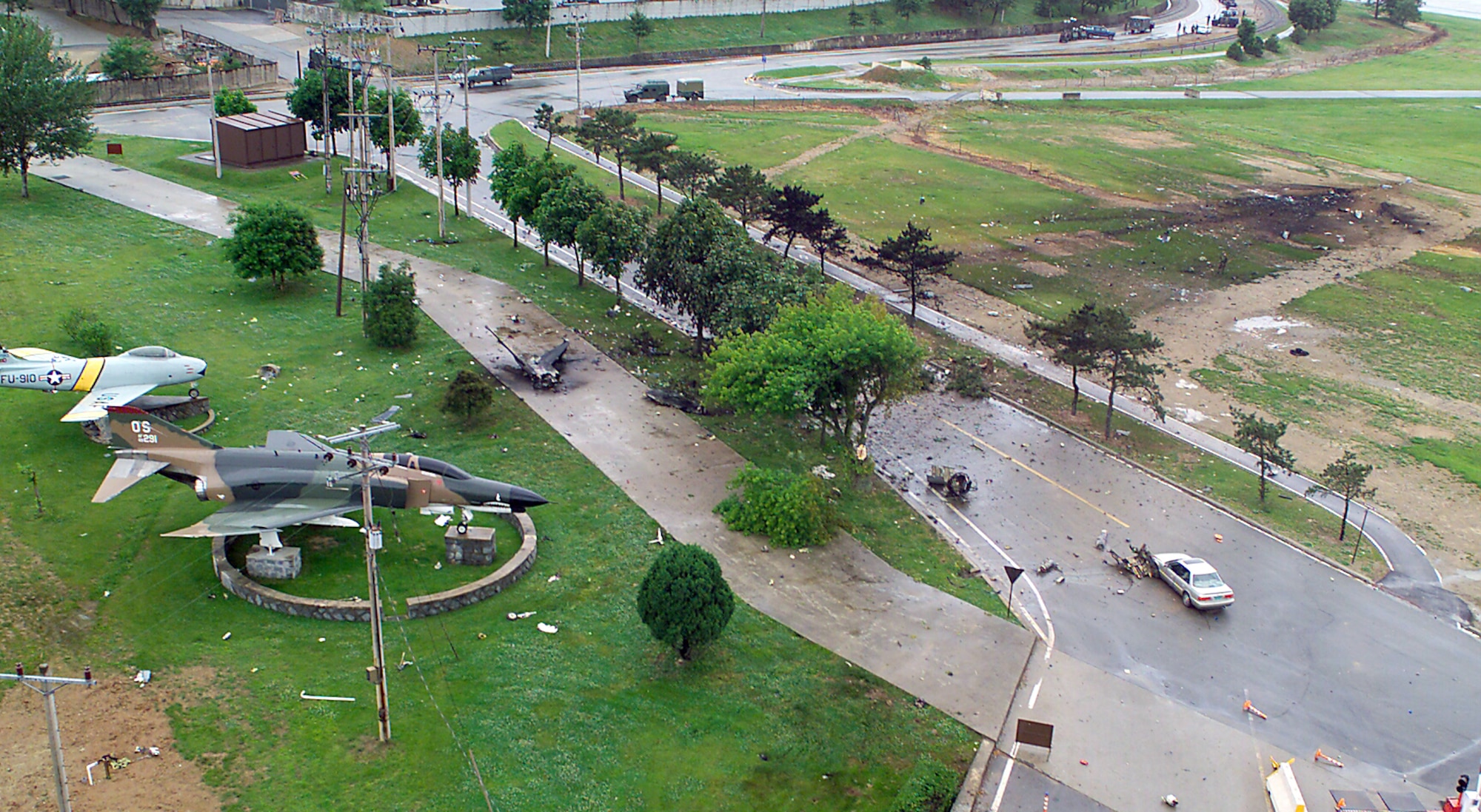 OSAN AIR BASE, South Korea -- Remnants of the Air Force F-16 Fighting Falcon lay scattered around aircraft static displays of an F-86 Sabre and F-4 Phantom near the base entrance.  A pilot from the 36th Fighter Squadron was taking off on a training mission in the F-16 when the crash occurred May 29.  (U.S. Air Force photo by Tech. Sgt. Alex Lloyd)