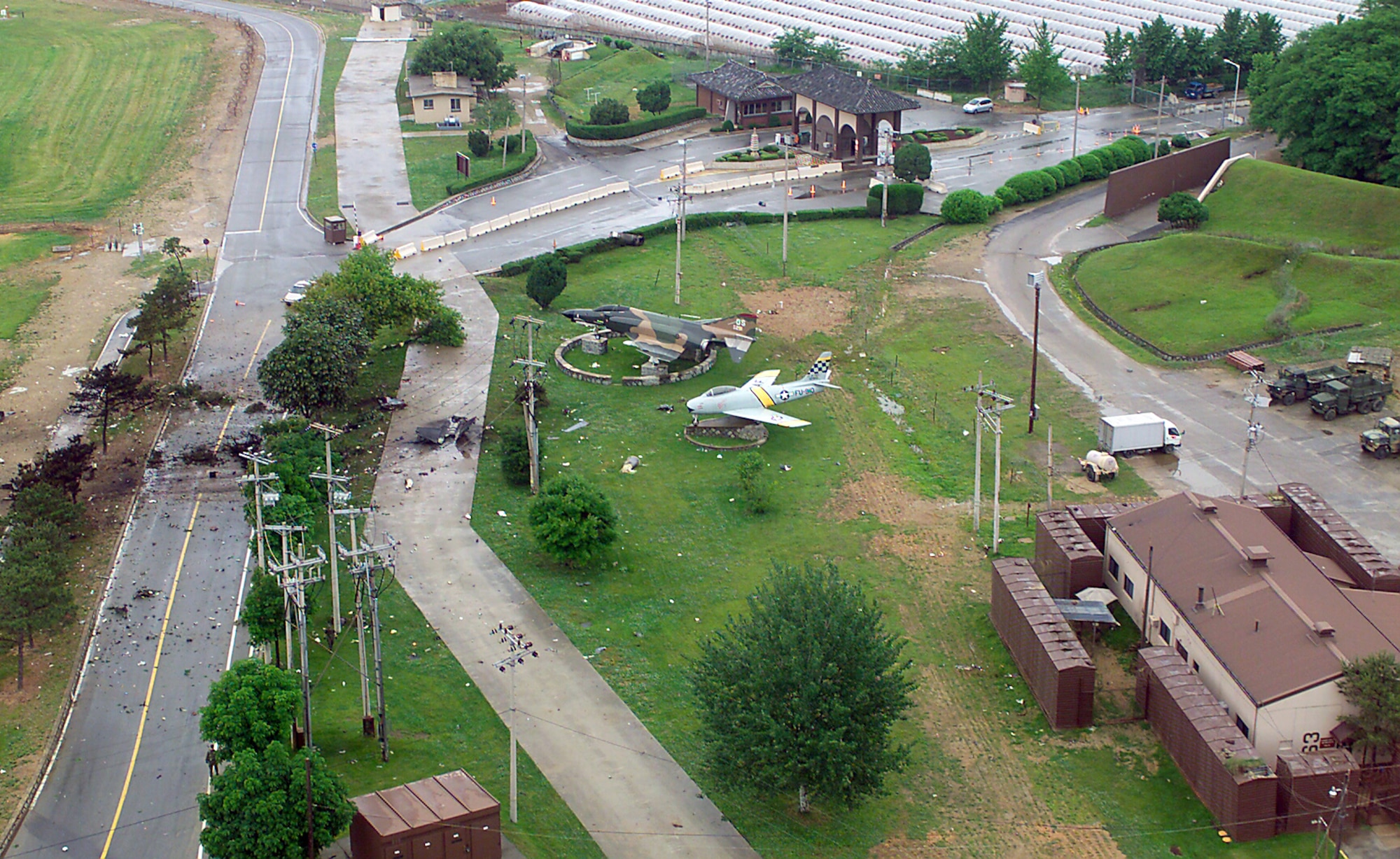 OSAN AIR BASE, South Korea -- Remnants of the Air Force F-16 Fighting Falcon lay scattered around aircraft static displays of an F-86 Sabre and F-4 Phantom near the base entrance.  A pilot from the 36th Fighter Squadron was taking off on a training mission in the F-16 when the crash occurred May 29.  (U.S. Air Force photo by Tech. Sgt. Alex Lloyd)