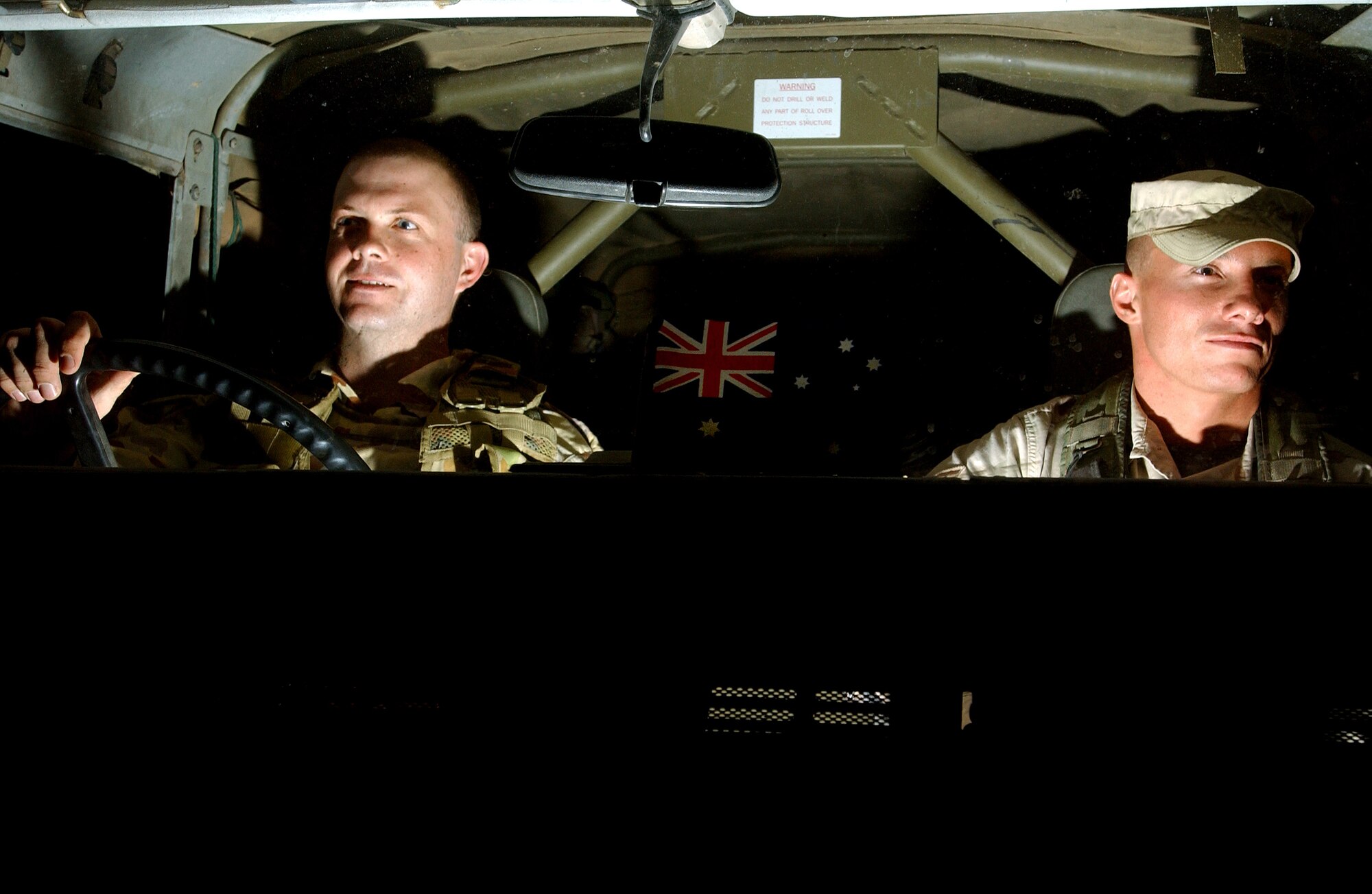 BAGHDAD INTERNATIONAL AIRPORT, Iraq -- Sgt. Nathan Hogg (left) and Senior Airman Sheridan Conklin conduct a night patrol here looking for any suspicious activity.  Hogg is a member of the Royal Australian Air Force, and Conklin is assigned to the 447th Expeditionary Security Forces Squadron.  Conklin is deployed here from the 9th Security Forces Squadron at Beale Air Force Base, Calif.  (U.S. Air Force photo by Airman 1st Class Brian Ferguson)