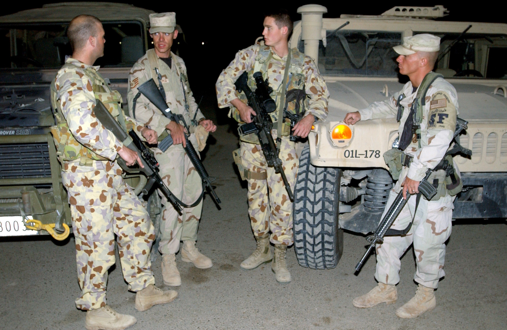 BAGHDAD INTERNATIONAL AIRPORT, Iraq -- (From left) Sgt. Nathan Hogg, Staff Sgt. Shawn Schwantes, Aircraftman Lucas Kilpatrick and Senior Airman Sheridan Conklin meet up during their air base defense patrol.  Hogg and Kilpatrick are members of the Royal Australian Air Force, and Schwantes and Conklin are assigned to the 447th Expeditionary Security Forces Squadron.  Schwantes is deployed from the 319th Security Forces Squadron at Grand Forks Air Force Base, N.D., and Conklin is deployed from the 9th SFS at Beale AFB, Calif.  (U.S. Air Force photo by Airman 1st Class Brian Ferguson)