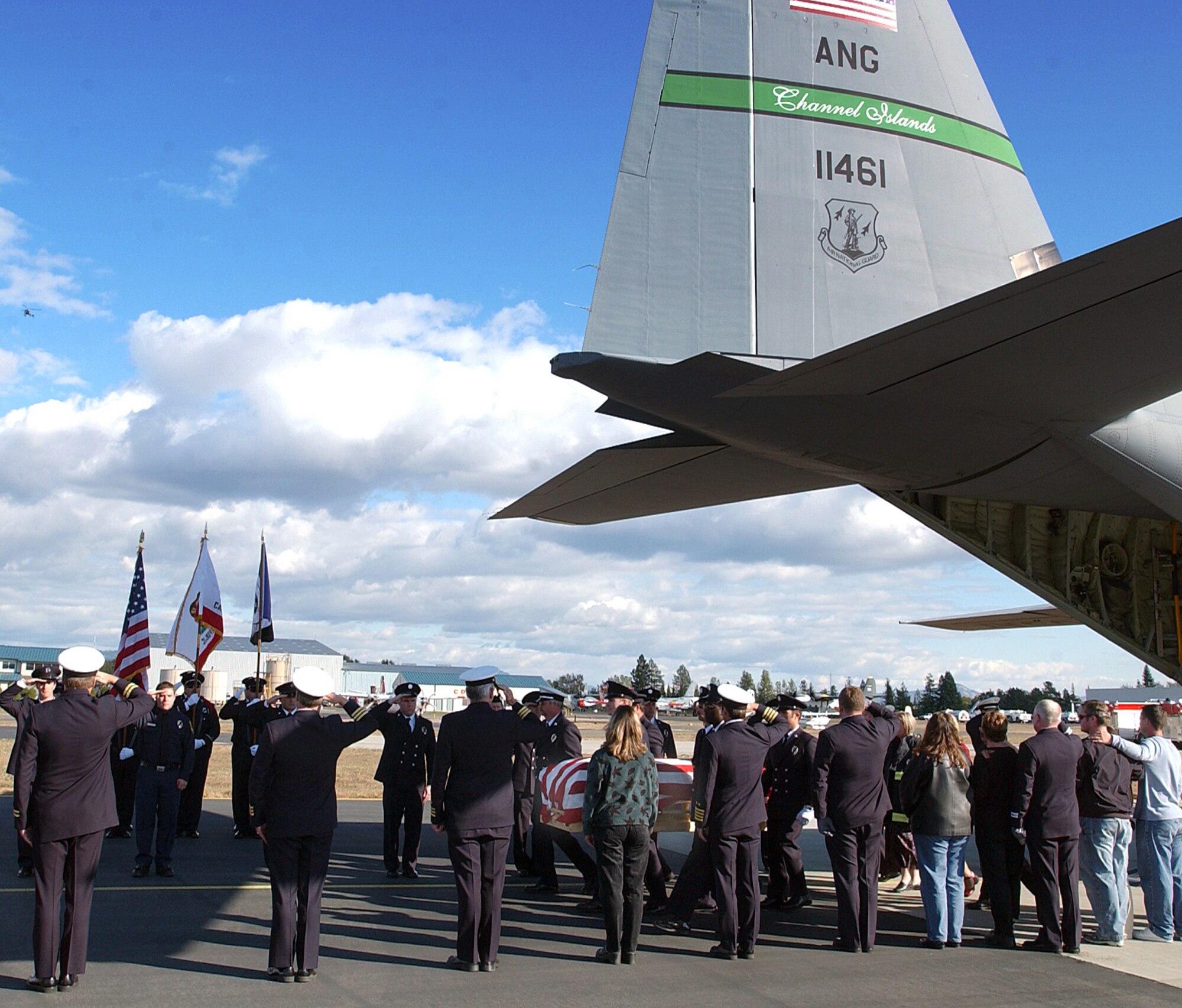 SANTA ROSA COUNTY AIRPORT, Calif.  -- Firefighters salute as the casket of firefighter Steven Rucker is taken from an Air Force C-130 Hercules here.  Rucker, an engineer with the Novato Fire Protection District, died Oct. 29 in San Diego County's Cedar fire.  (U.S. Air Force photo by Staff Sgt. Alex J. Koenig)