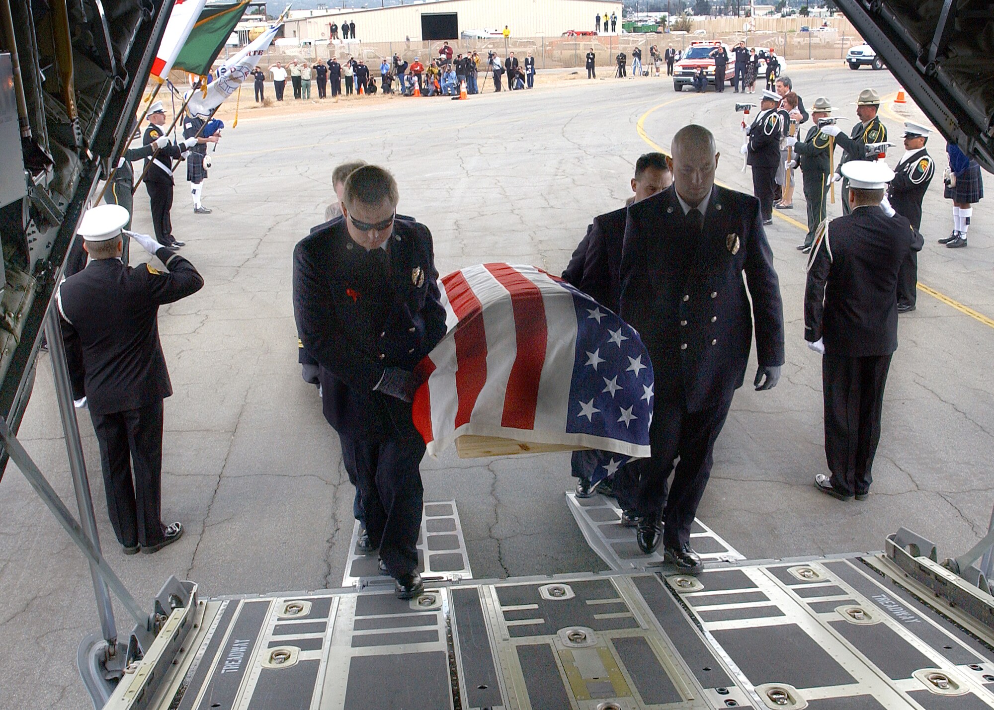 GILLESPIE FIELD AIRPORT, Calif.  -- Novato firefighters Shawn Kreps (left) and Barrett Smith lead pallbearers carrying the casket of firefighter Steven Rucker into the cargo area of an Air Force C-130 Hercules here.  Rucker, an engineer with the Novato Fire Protection District, died Oct. 29 in San Diego County's Cedar fire.  Kreps, Smith and Capt. Doug McDonald survived the fire that claimed Rucker's life.  (U.S. Air Force photo by Staff Sgt. Alex J. Koenig)