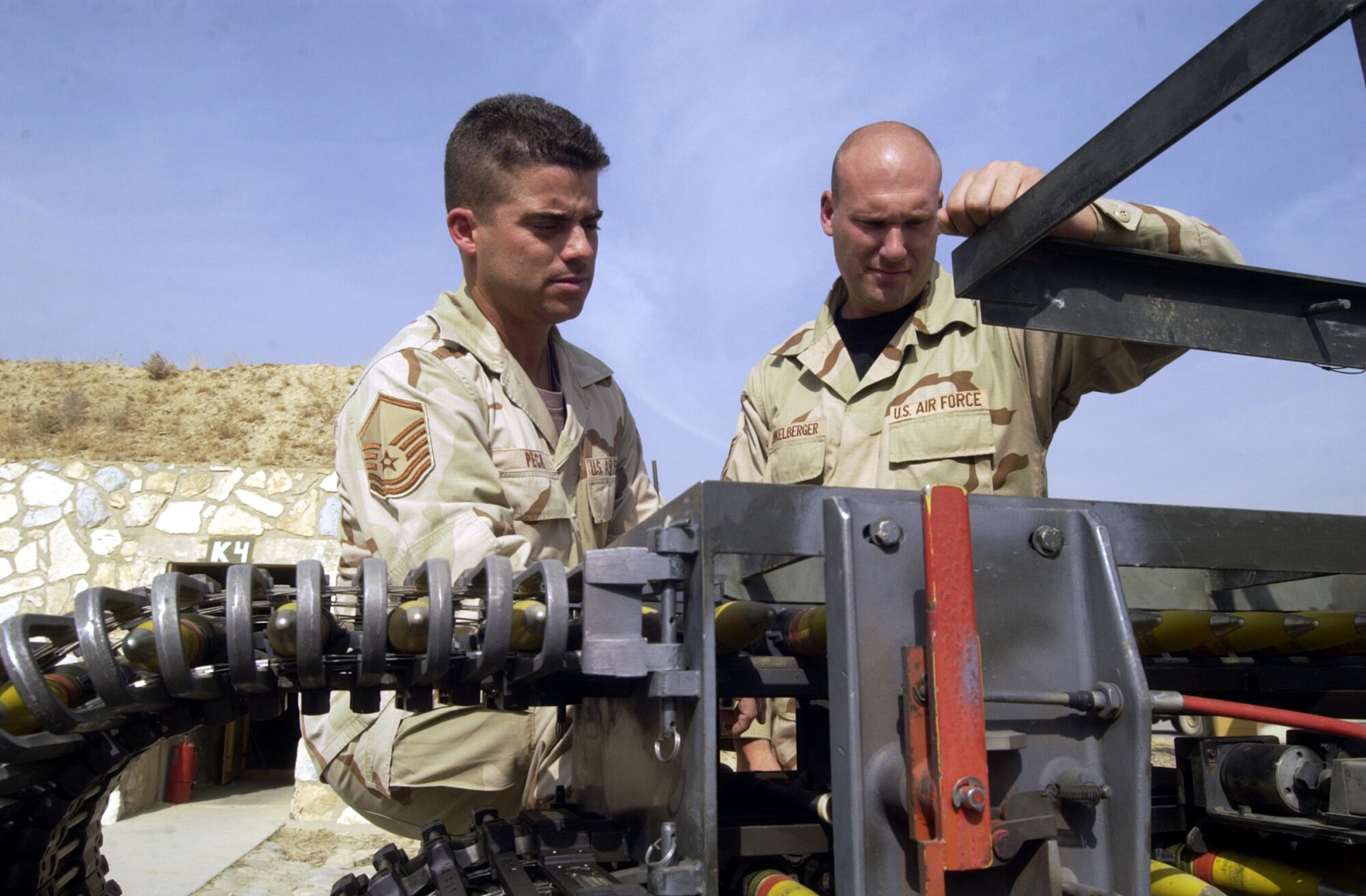BAGRAM AIR BASE, Afghanistan -- Master Sgt. Marc Peck (left) and Tech. Sgt. Duren Dunkelberger inspect 30 mm ammunition rounds for defects as they pass by on a loading machine.  The rounds will be loaded on an A-10 Thunderbolt II for combat here.  Peck and Dunkelberger are assigned to the 455th Expeditionary Operations Group.  Peck is part of Air and Space Expeditionary Force Blue deployed from Spangdahlem Air Base, Germany.  Dunkelberger is part of AEF Silver deployed from Davis-Monthan Air Force Base, Ariz.  Airmen with AEF Silver are replacing those with AEF Blue.  (U.S. Air Force photo by Staff Sgt. Russell Wicke)