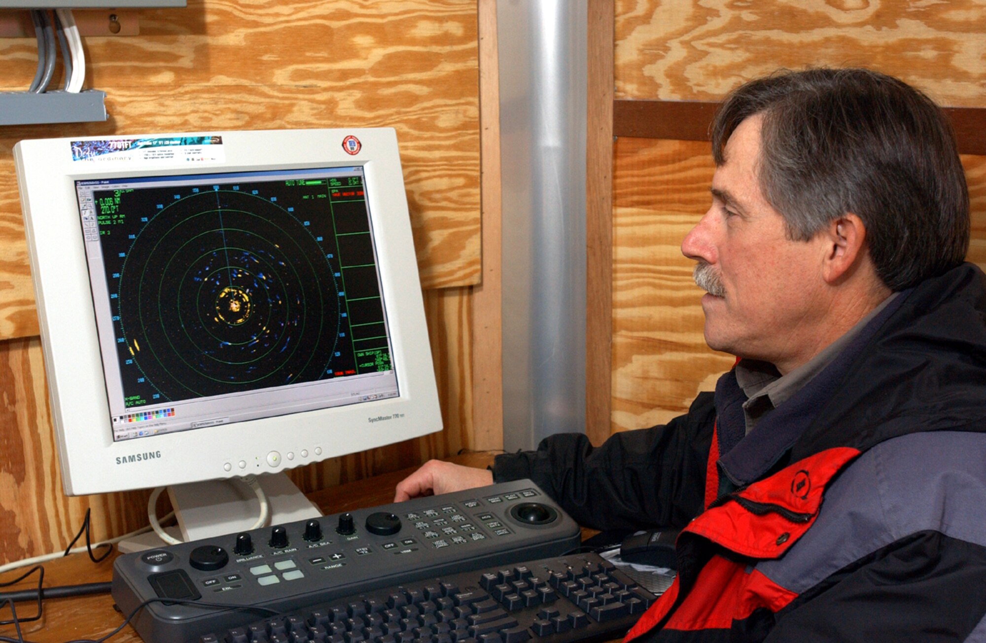 ELMENDORF AIR FORCE BASE, Alaska -- Herman Griese monitors the bird radar here Nov. 5.  The mobile bird-radar system is contained in a small trailer and is connected to a revolving satellite dish by a 100-foot umbilical cord.  The system allows wildlife experts to observe and document patterns of bird activity.  Griese is a wildlife biologist with the 3rd Civil Engineer Squadron.  (U.S. Air Force photo by Staff Sgt. David Donovan)
