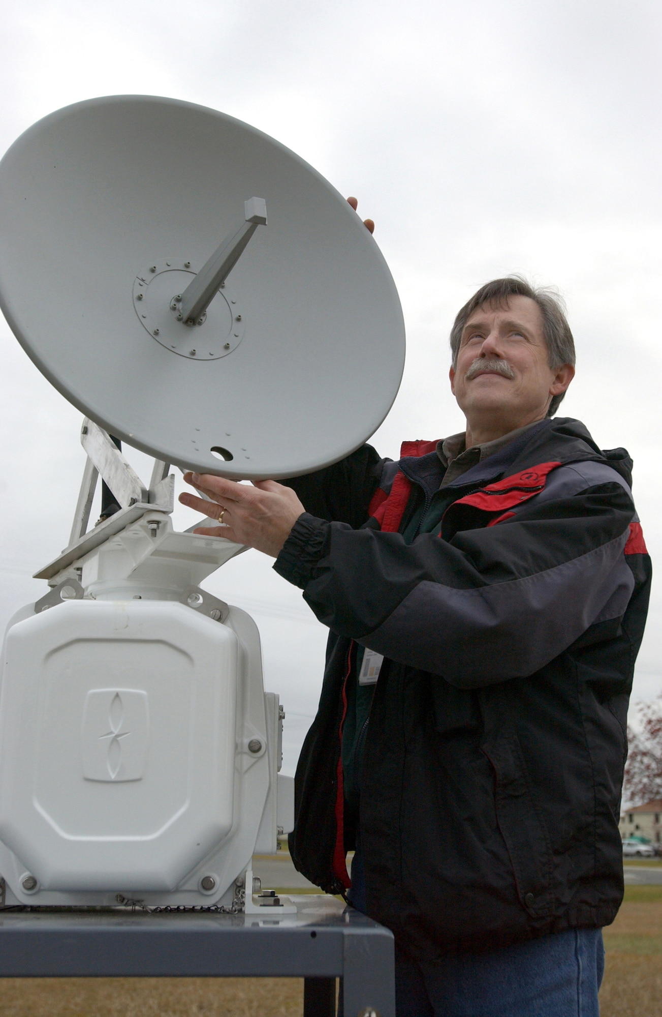 ELMENDORF AIR FORCE BASE, Alaska -- Herman Griese adjusts the satellite dish for the base's bird-radar system.  The mobile system is contained in a small trailer and is connected to a revolving satellite dish by a 100-foot umbilical cord.  It will allow wildlife experts to observe and document patterns of bird activity.  Griese is a wildlife biologist with the 3rd Civil Engineer Squadron.  (U.S. Air Force photo by Staff Sgt. David Donovan)