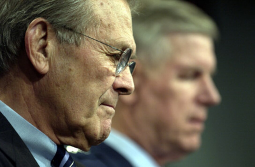 Secretary of Defense Donald H. Rumsfeld and Chairman of the Joint Chiefs of Staff Gen. Richard B. Myers, U.S. Air Force, listen to a reporter's question about troop rotation during a Pentagon press briefing on Nov. 6, 2003. Rumsfeld and Myers announced the force rotation, which will include approximately 85,000 active duty and 43,000 reservists from all services deployed in support of Operations Enduring Freedom and Iraqi Freedom. 