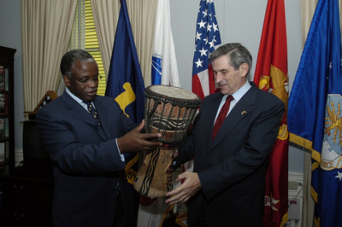 Minister of Defense Amama Mbabazi of Uganda presents a drum as a gift to Deputy Secretary of Defense Paul Wolfowitz on Nov. 7, 2003. Mbabazi traveled to the Pentagon to meet with leaders on defense issues of mutual interest. 