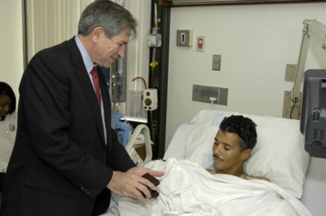Deputy Secretary of Defense Paul Wolfowitz visits with Sgt. 1st Class Joseph Briscoe at Walter Reed Army Medical Center on Nov. 11, 2003. Wolfowitz visited Briscoe and other wounded soldiers from Iraq and Afghanistan before joining President Bush at Arlington National Cemetery for the traditional Veterans Day observances. Briscoe, a 16-year Army veteran, was seriously wounded when a rocket-propelled grenade hit his vehicle in Iraq. 