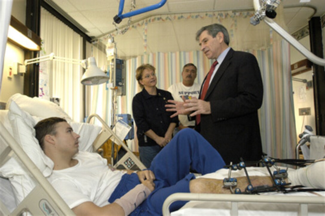 Deputy Secretary of Defense Paul Wolfowitz (right) talks with Army Pfc. Christopher Busby and his parents Carole and Kenneth Busby at Walter Reed Army Medical Center in Washington, D.C., on Nov. 11, 2003. Busby was wounded by enemy mortar fire while serving in Iraq. Wolfowitz visited soldiers wounded in Iraq and Afghanistan at the hospital before joining President Bush at Arlington National Cemetery for the traditional Veterans Day observances. 