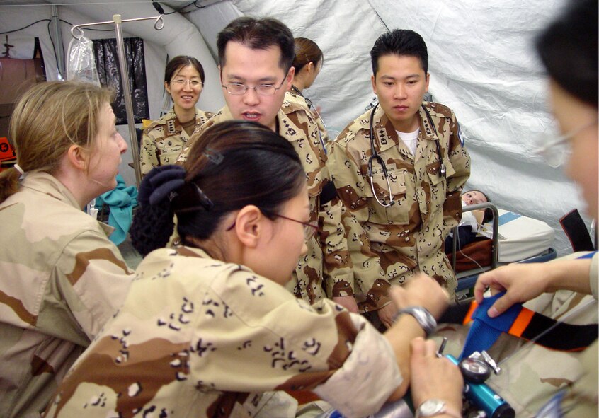 MANAS AIR BASE, Kyrgyzstan -- Members of the 376th Expeditionary Medical Group and South Korea's 924th Medical Group work together on a simulated patient during an exercise at the hospital here.  (South Korean army photo by Cpl. Hongyeon Kim)