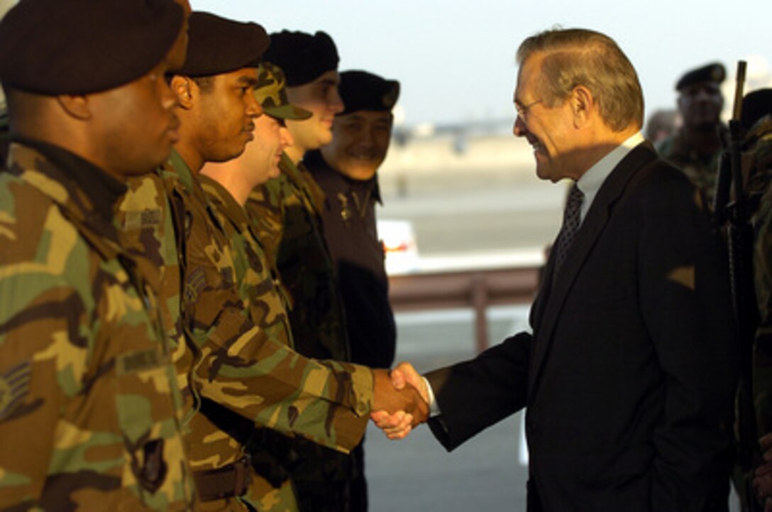 Secretary of Defense Donald H. Rumsfeld shakes hands with Air Force Security Forces airmen while visiting Yokota Air Base, Japan, on Nov. 15, 2003. Rumsfeld is traveling to Guam, Japan and South Korea to meet with U.S. military forces and the local military and civilian leadership. 