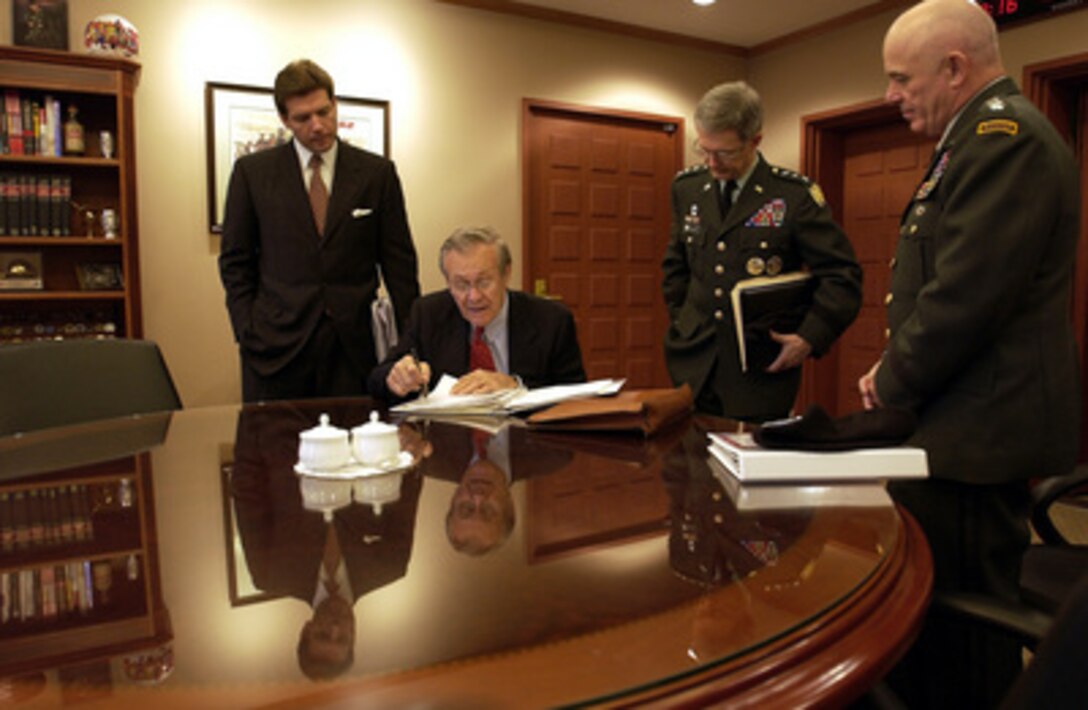 Secretary of Defense Donald H. Rumsfeld (seated) discusses some paperwork with Acting Assistant Secretary of Defense Public Affairs Lawrence Di Rita (left), Army Lt. Gen. John Craddock (center) and Gen. Leon J. La Porte (right) at the beginning of his day in Seoul, South Korea, on Nov. 17, 2003. Rumsfeld is traveling to Guam, Japan and South Korea to meet with U.S. military forces and the local military and civilian leadership. Craddock is the senior military assistant to the Secretary of Defense. La Porte is the commander of U.S. Forces Korea. 