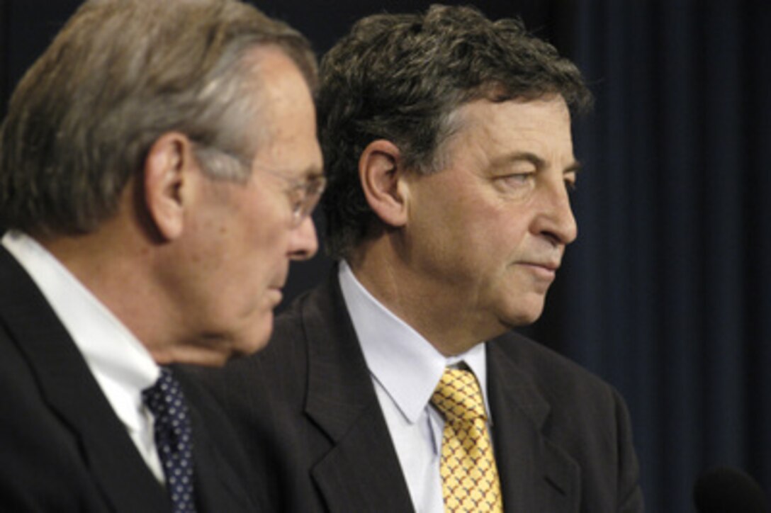 Australia's Minister for Defense Robert M. Hill (right) and Secretary of Defense Donald H. Rumsfeld (left) listen to a reporter's question during a joint media availability in the Pentagon on Nov. 19, 2003. Earlier the two defense leaders met to discuss a range of security issues of interest to both nations. 
