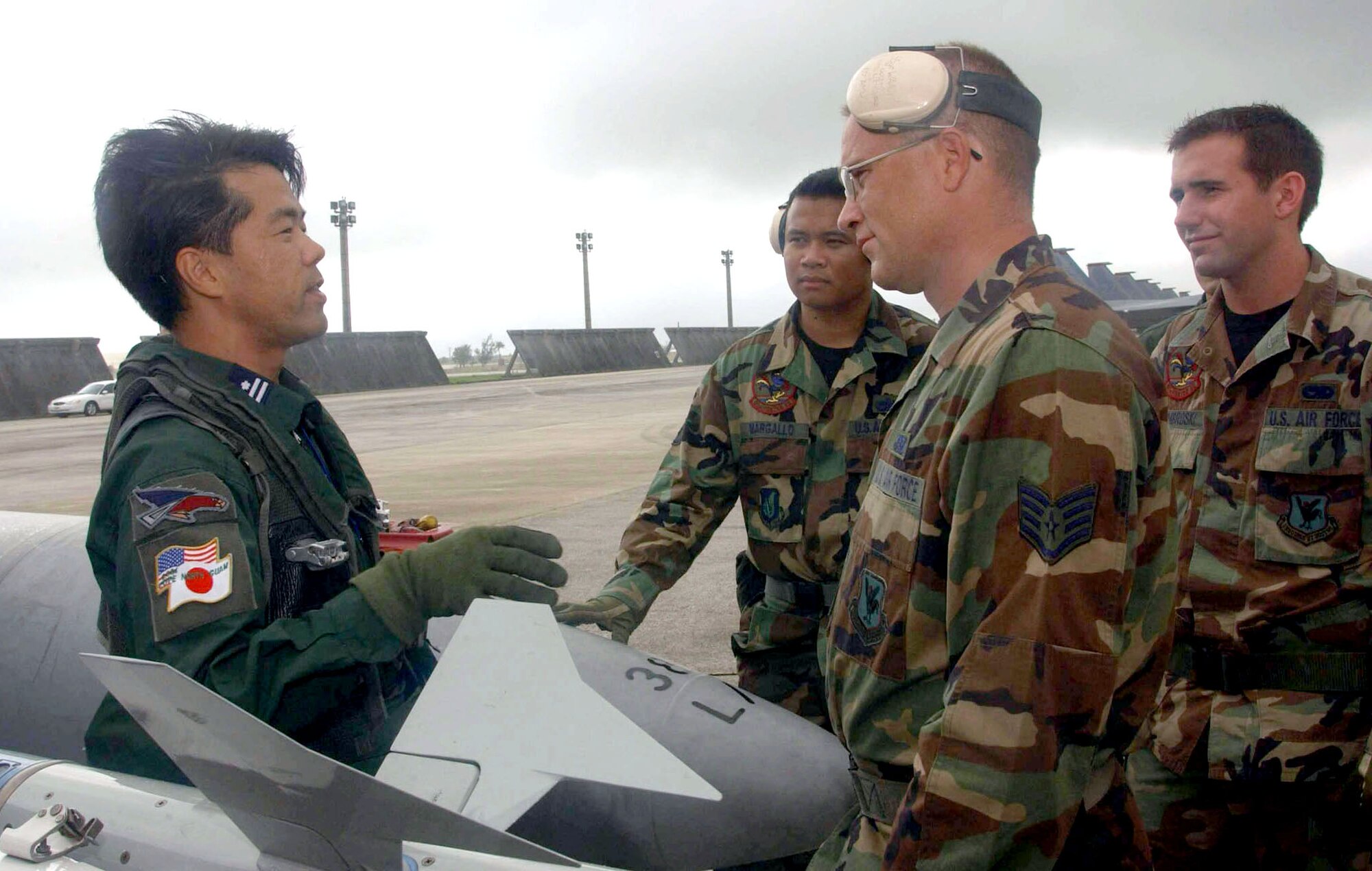 ANDERSEN AIR FORCE BASE, Guam -- Japanese Maj. Hideaki Yoshizawa explains the features of his aircraft to Staff Sgts. Martin Waack (foreground), Lucilio Margallo (left) and Senior Airman Joseph Dombroski during exercise Cope North.  Waack, Margallo and Dombroski are crew chiefs from the 67th Aircraft Maintenance Unit at Kadena Air Base, Japan.  Hideaki is an F-4 fighter pilot from the 83rd Wing at Naha Air Base, Japan.  (U.S. Air Force photo by Master Sgt. Val Gempis)

