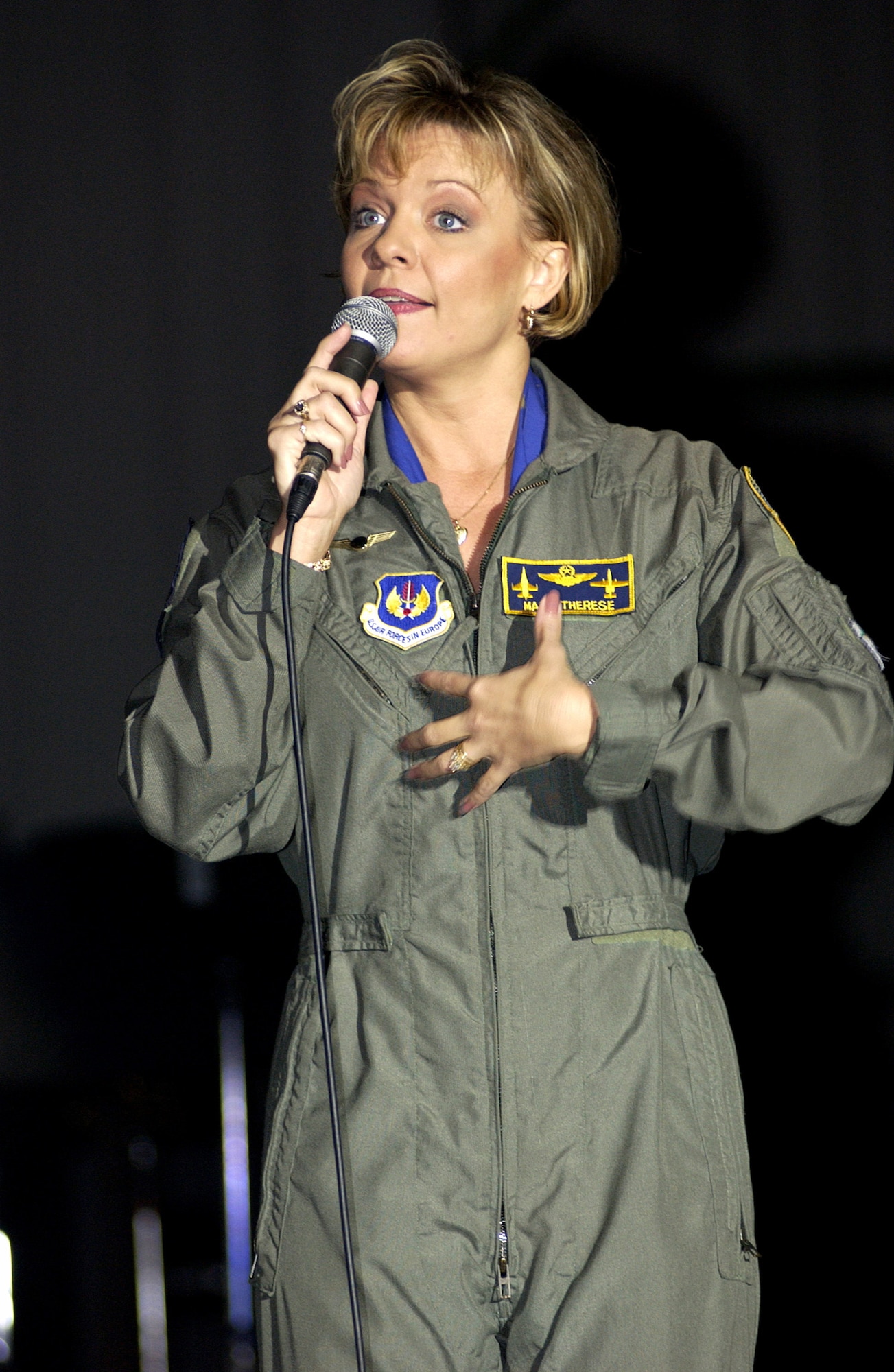 LAJES FIELD, Azores -- Mary Therese Tebbe thanks the crowd during a concert event here Nov. 18.  Tebbe, country-music group Restless Heart, Comedian Andy Andrews and the New England Patriot Cheerleaders are touring Europe with the Air Force Reserve Band as part of a United Services Organizations holiday tour called Operation Seasons Greetings.  Tebbe is an anchorwoman for a television station in Macon, Ga.  (U.S. Air Force photo by Tech. Sgt. Robert W. Valenca)