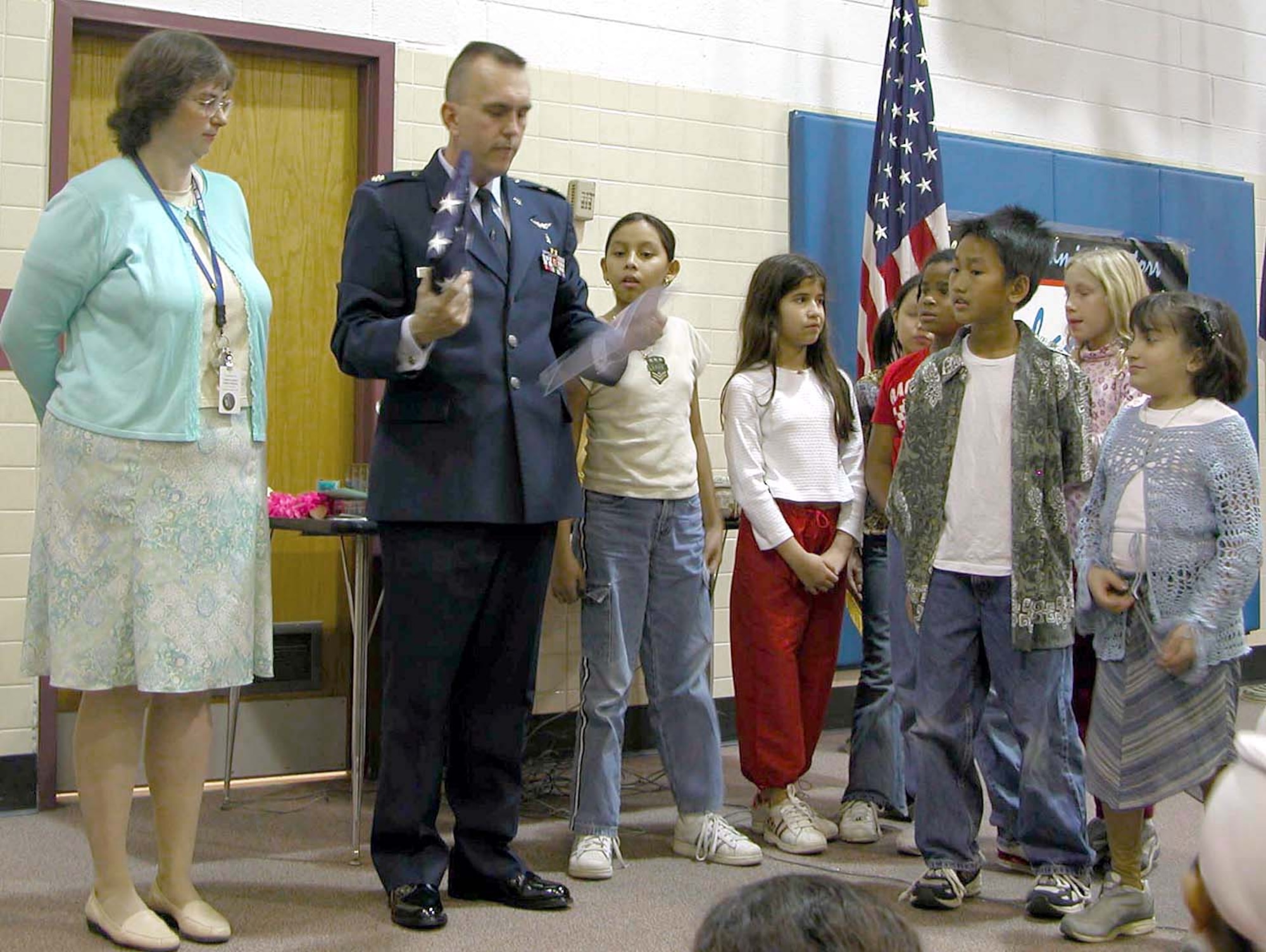 WASHINGTON -- For their support and appreciation for being "Baghdad Buddies" to the 11th Medical Group, Maj. Mike Lundy presented Bren Mar Park Elementary School students with a U.S. flag Nov. 21 that had been flown over Baghdad International Airport.  Lundy was deployed to Baghdad for four months.  He is the chief of public health at Bolling Air Force Base, D.C.  (U.S. Army photo by Sgt. 1st Class Doug Sample)