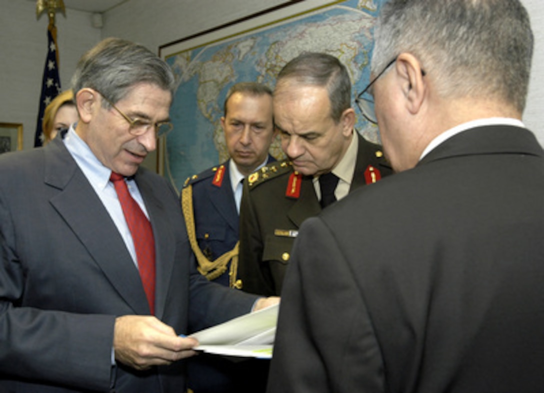 Deputy Secretary of Defense Paul Wolfowitz (left) looks over the transcript of President Bush's comments concerning the terrorist bombings in Istanbul, Turkey, with Deputy Chief of the Turkish General Staff Gen. Ilker Basbug (right), Brig. Gen. Beyazit Karatas (center), the Turkish defense attaché', and Turkish Ambassador Faruk Logoglu (foreground) before going to speak to reporters during a joint media availability on Nov. 20, 2003. Wolfowitz met with the Turkish delegation in the Pentagon to discuss the recent terrorist activity and other matters of mutual interest. 