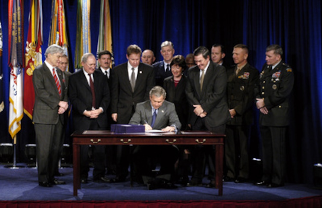 President George W. Bush (seated) is surrounded by members of Congress and senior Defense Department leaders as he signs the National Defense Authorization Act at the Pentagon on Nov. 24, 2003. The Act provides $401.3 billion for the Department of Defense, which will allow for continued support of the missions of the U.S. Military and its men and women serving around the globe. 