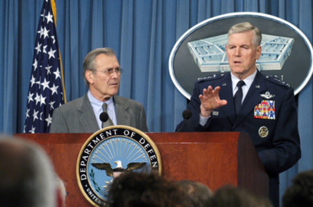 Secretary of Defense Donald H. Rumsfeld listens to Chairman of the Joint Chiefs of Staff Gen. Richard B. Myers, U.S. Air Force, as he provides additional comments to a reporter during a press conference in the Pentagon on Nov. 25, 2003. Rumsfeld and Myers gave opening statements then fielded a broad range of questions from reporters. 