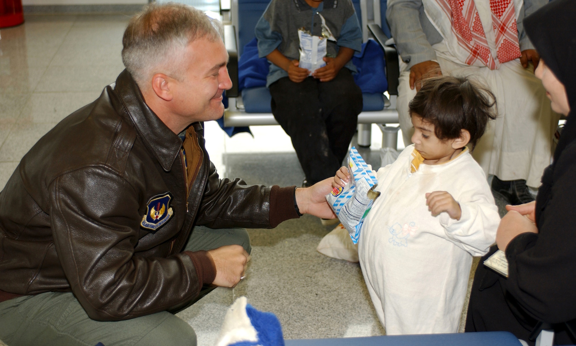 RAMSTEIN AIR BASE, Germany -- Brig. Gen. Erwin F. Lessel III hands a snack to one of 18 Iraqi children who arrived here Oct. 6.  The children were flown in by the Air Force from Baghdad International Airport to receive medical care from hospitals throughout Rheinland-Pfalz, Germany.  Lessel is the 86th Airlift Wing commander here.  (U.S. Air Force photo by Airman Steve Czyz)