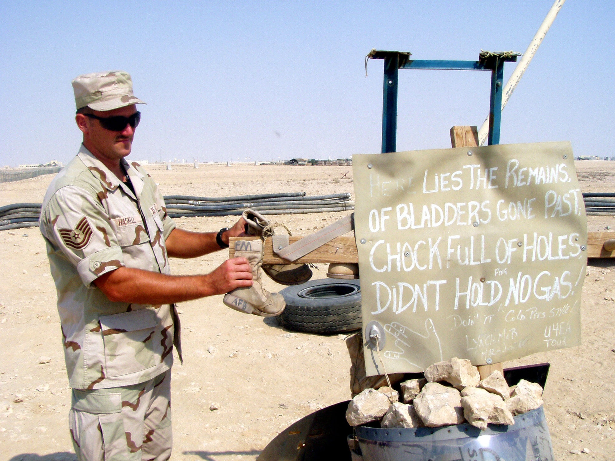 AL UDEID AIR BASE, Qatar -- Tech. Sgt. Jack Haskell helps add finishing touches to the Boot Hill "cemetery" here.  Legend has it that if a troop "buries" boots there, he or she will never have to return to the base. Haskell is deployed here from Seymour Johnson Air Force Base, N.C., and is currently assigned to the 379th Expeditionary Logistics Readiness Squadron.  (U.S. Air Force photo by Master Sgt. William J. Sharp)