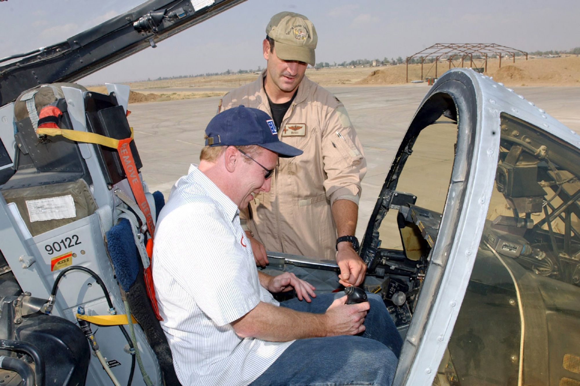 KIRKUK AIR BASE, Iraq -- Maj. Mark Ernewein explains the A-10 Thunderbolt II's equipment to comedian Butch Bradley during a tour here Oct. 2.  Four comedians from the USO Laugh Factory Comedy Tour entertained more than 300 Kirkuk residents.  Ernewein is assigned to the 303rd Fighter Squadron.  (U.S. Air Force photo by Tech. Sgt. Charlein Sheets)
