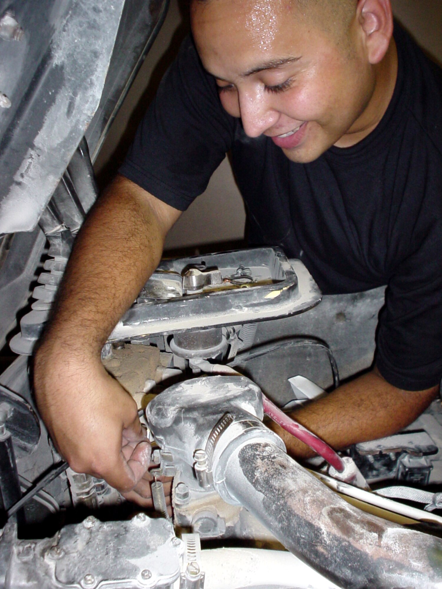 AL UDEID AIR BASE, Qatar -- Senior Airman Samuel J. Rios replaces a forklift throttle cable inside a vehicle maintenance shop Sept. 29.  Rios is a special-purpose mechanic assigned to the 379th Expeditionary Logistics Readiness Squadron here.  He is deployed from McGuire Air Force Base, N.J.  (U.S. Air Force photo by Master Sgt. William J. Sharp)