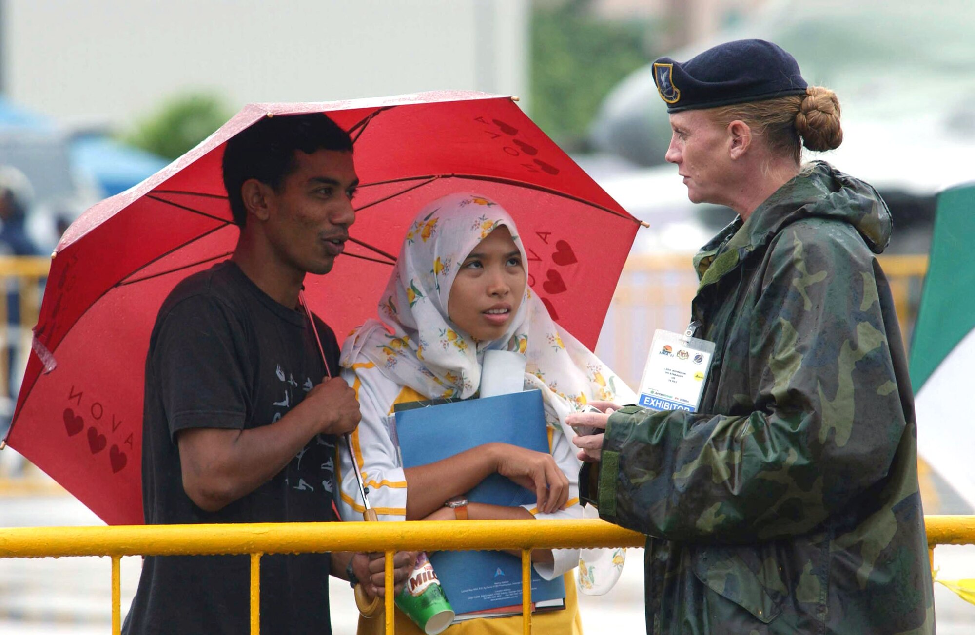 LANGKAWI, Malaysia -- Tech. Sgt. Lisa Johnson chats with Malaysians at the flightline during the Langkawi International Maritime and Aerospace 2003 exhibition here.  She is from the 613th Security Forces Squadron at Andersen Air Force Base, Guam.  LIMA is one of the premier defense trade shows in the world and this year featured defense-related technology from more than 800 companies in some 40 nations.  (U.S. Air Force photo by Master Sgt. Val Gempis)