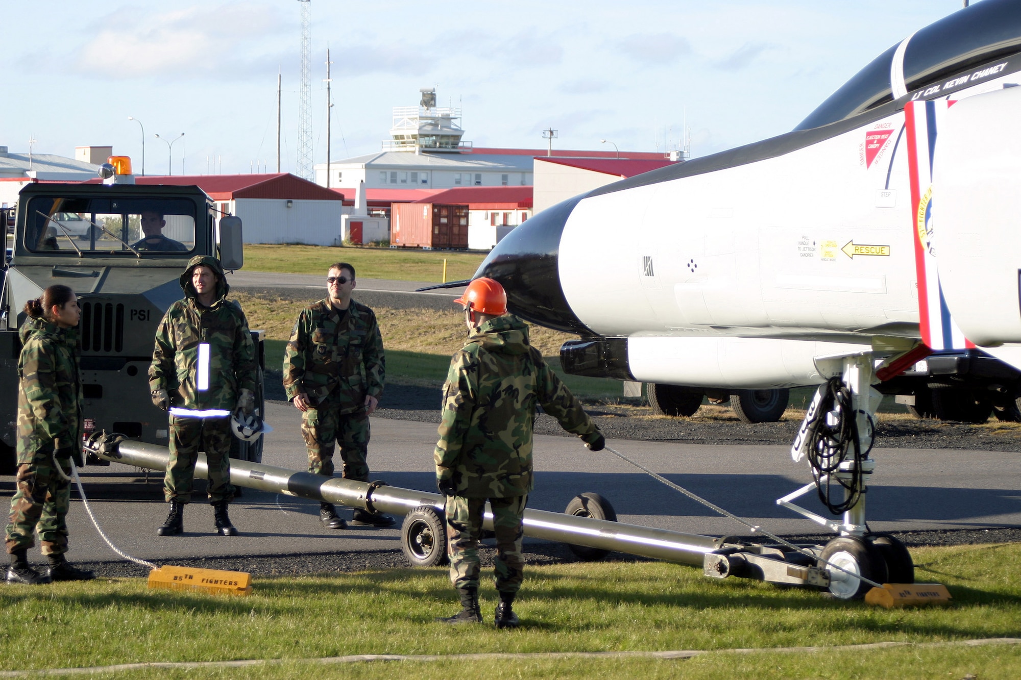 NAVAL AIR STATION KEFLAVÍK, Iceland -- Airmen from the 85th Group here remove the tow bar connected to an F-4 Phantom.  The aircraft, which has been on display since the early 1990s, was removed from its pedestal in 2002 because of extensive corrosion.  It was restored and put on display in front of the command building.  (U.S. Navy photo by JO2 Mat Sohl)