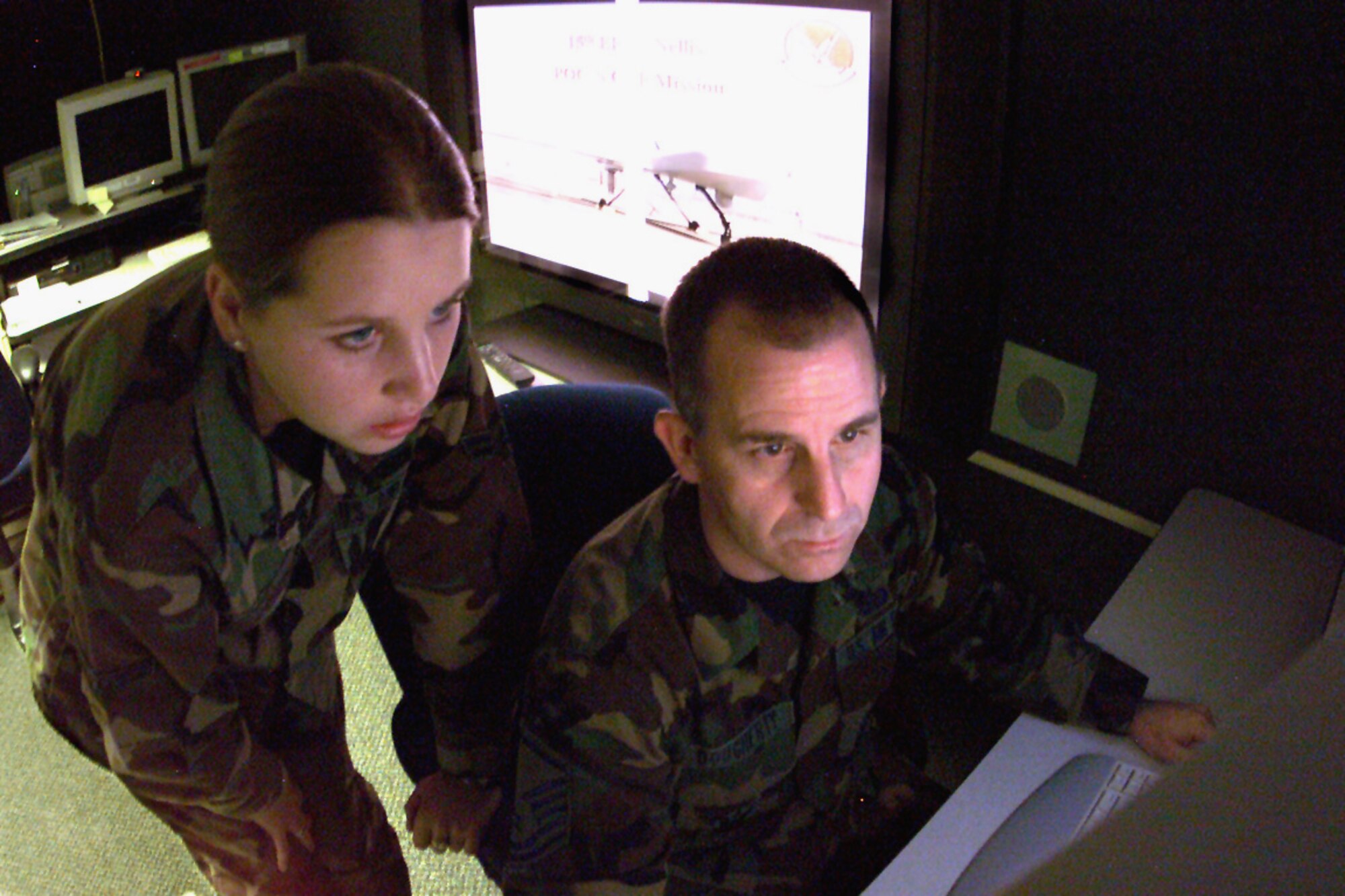 LANGLEY AIR FORCE BASE, Va. -- Airman 1st Class Jamie O'Connell, an imagery analyst in the 30th Intelligence Squadron here, consults with Master Sgt. William Dougherty, an imagery mission supervisor to interpret data from a Predator image feed.  Dougherty is deployed from the Arkansas Air National Guard's 123rd IS.  O'Connell and Dougherty are part of a team that provides intelligence, surveillance and reconnaissance feedback to deployed warfighting commanders.  (U.S. Air Force photo by Staff Sgt. Brendan Kavanaugh)