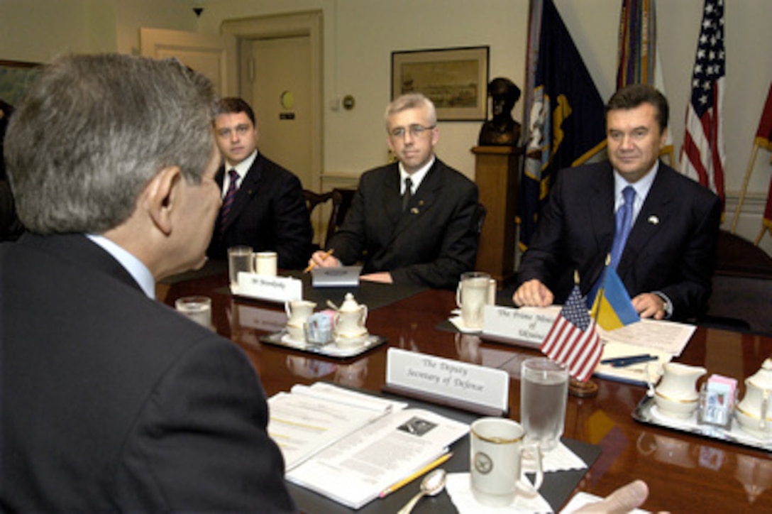 Ukrainian Prime Minister Victor Yanukovych (right) meets with Deputy Secretary of Defense Paul Wolfowitz (foreground) in the Pentagon on Oct. 9, 2003. Yanukovych and Wolfowitz are meeting to discuss a range of national and international security issues. Also participating in the talks on the Ukrainian side are Eduard Prutnik (left), advisor to the prime minister, and Volodymyr Yatsenkivsky (center) the charge d' affaires at the Ukrainian Embassy. 