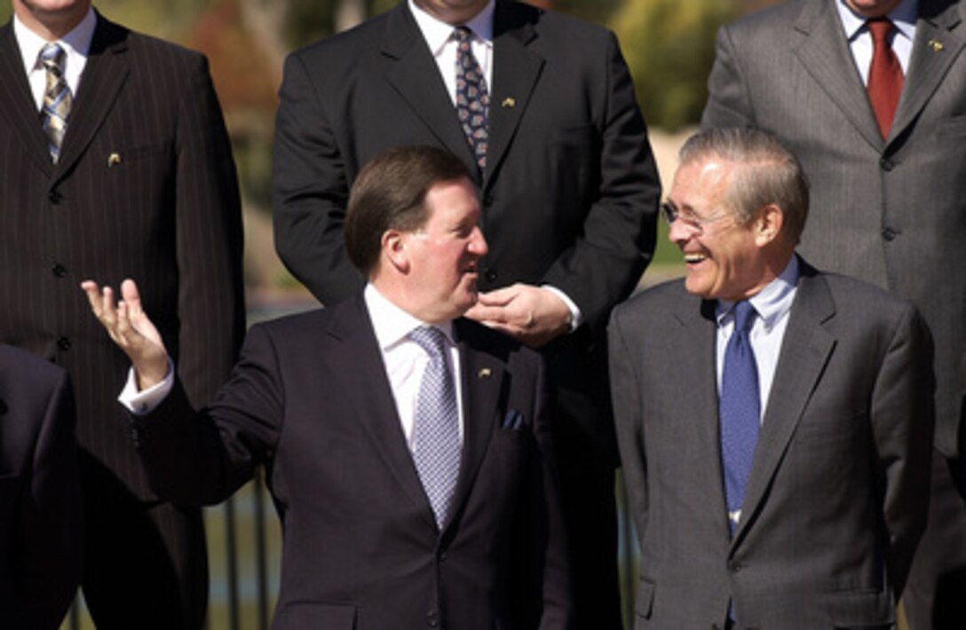 NATO Secretary General Lord Robertson (left) gestures while speaking with Secretary of Defense Donald H. Rumsfeld prior to the group photo session of NATO defense ministers at the Broadmoor Hotel in Colorado Springs, Colo., Oct. 9, 2003. Rumsfeld was the host for the two days of informal meetings in which the NATO members and representatives from 7 invited countries reviewed the Alliance's ongoing transformation. 