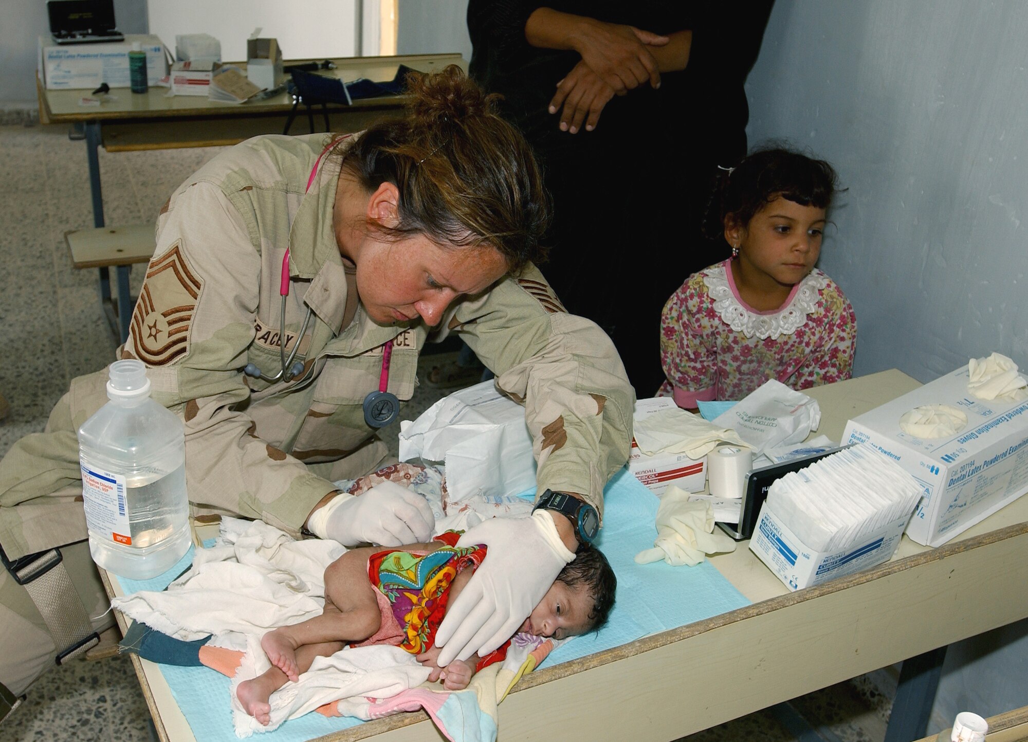 SWABE, Iraq -- Senior Master Sgt. Tommie Tracey treats a young infant's bedsores here during a medical and humanitarian assistance mission.  Tracey is deployed with the101st Expeditionary Rescue Squadron from the Air National Guard's 122nd Medical Group, in Fort Wayne, Ind.  (U.S. Air Force photo by Master Sgt. Robert R. Hargreaves Jr.)