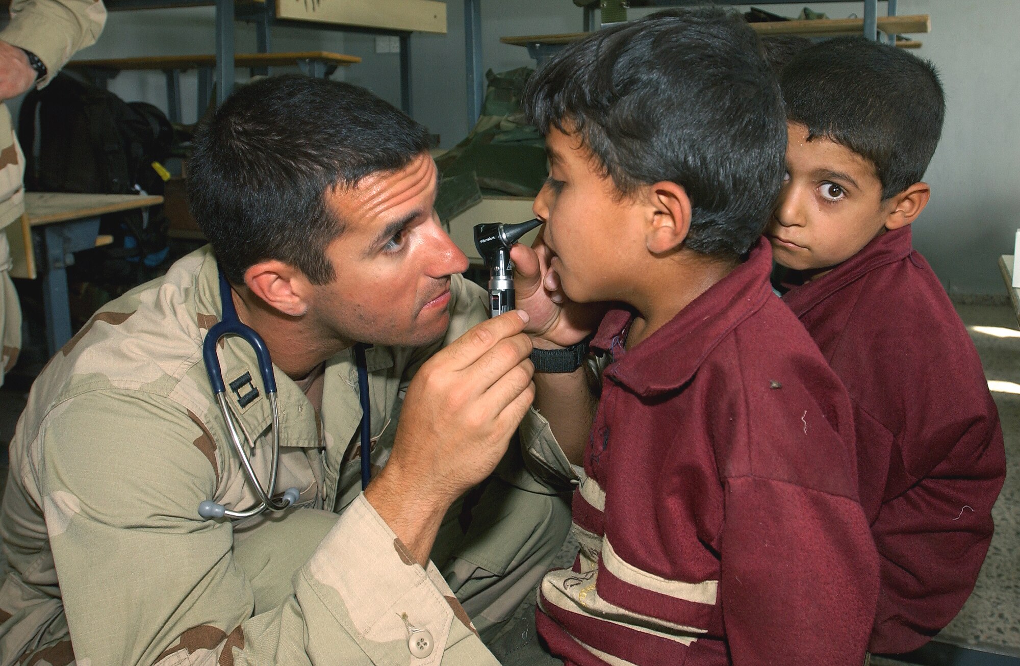 SWABE, Iraq -- Capt. Jeff Skinner examines a young Iraqi boy here during a medical and humanitarian assistance mission.  Skinner is deployed with the 101st Expeditionary Rescue Squadron from Langley Air Force Base, Va.  (U.S. Air Force photo by Master Sgt. Robert R. Hargreaves Jr.)