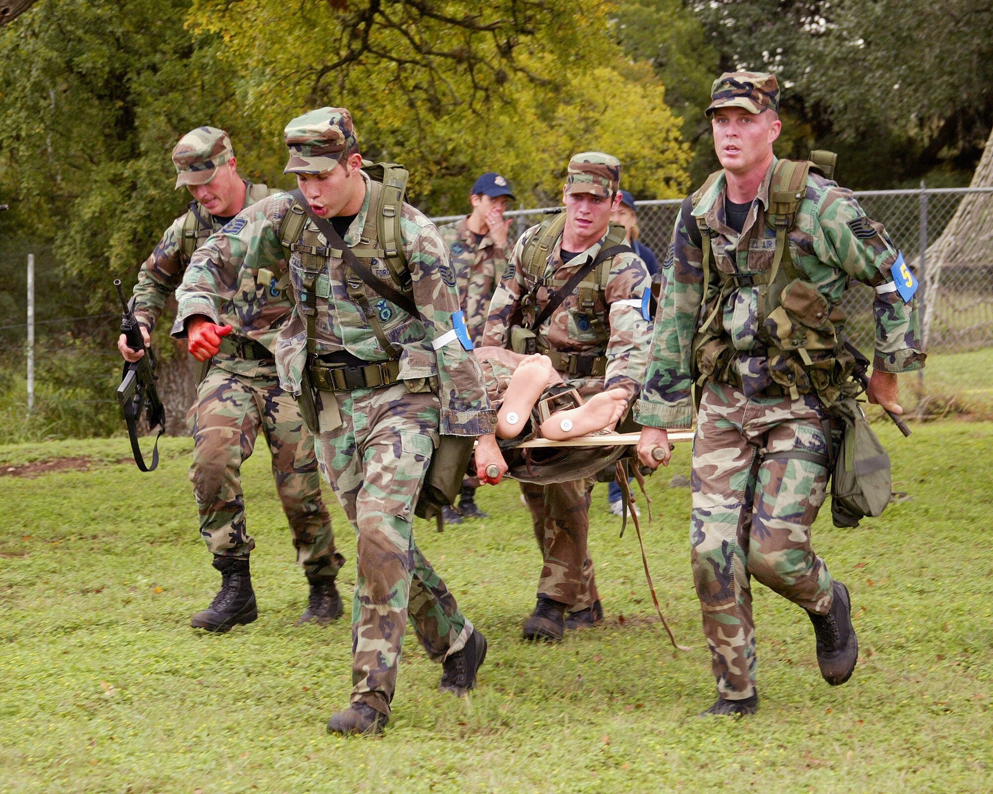 CAMP BULLIS, Texas -- Defender Challenge competitors from the Air Education and Training Command team move a "battlefield casualty" mannequin to the evacuation staging area.  The action took place during the Warrior Challenge event, which the AETC team won.  Team members pictured are (left to right) 2nd Lt. Matt Gravelink from the 56th Security Forces Squadron at Luke Air Force Base, Ariz.; Staff Sgts. Marco Talamantez and Vance Smith from the 37th SFS at Lackland AFB, Texas; and Tech. Sgt. Danile Hoyme from the 342nd Training Squadron at Lackland.  (U.S. Air Force photo by Robbin Cresswell)