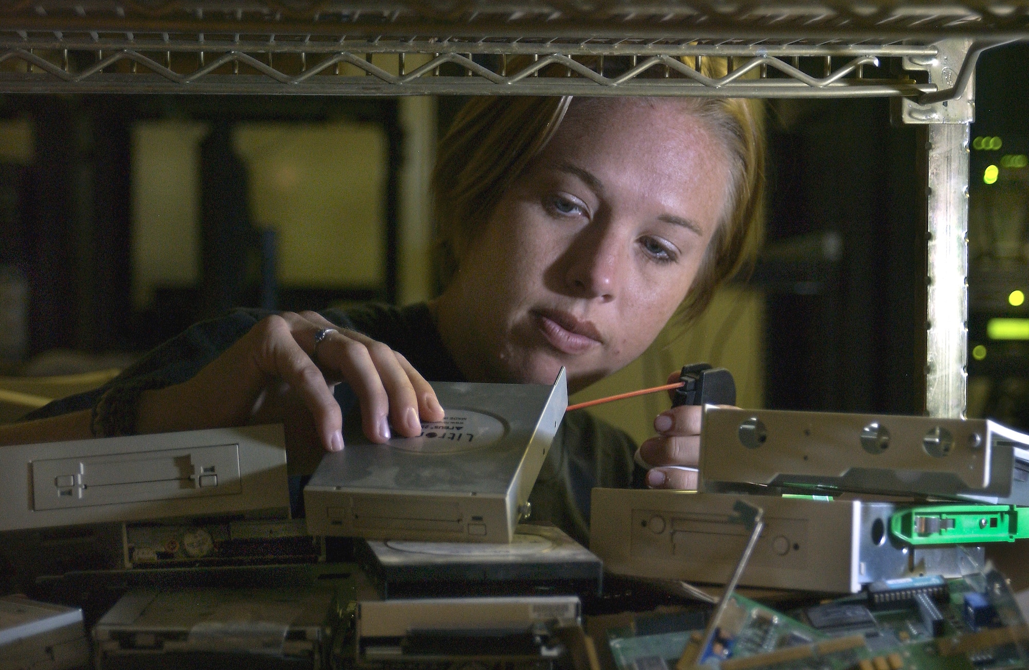 BAGHDAD INTERNATIONAL AIRPORT, Iraq -- Staff Sgt. Karen Riley works to salvage a working hard drive to rebuild a computer by taking apart each computer to test its internal components.  When enough working components are found, she pieces together a like-new computer.  She is deployed here as part of the 447th Expeditionary Communication Squadron, which is responsible for running the network control center and keeping the Air Force in Baghdad online.  Riley is a computer maintenance technician from the 22nd Communications Squadron at McConnell Air Force Base, Kan.  (U.S. Air Force photo by Master Sgt. Keith Reed)
