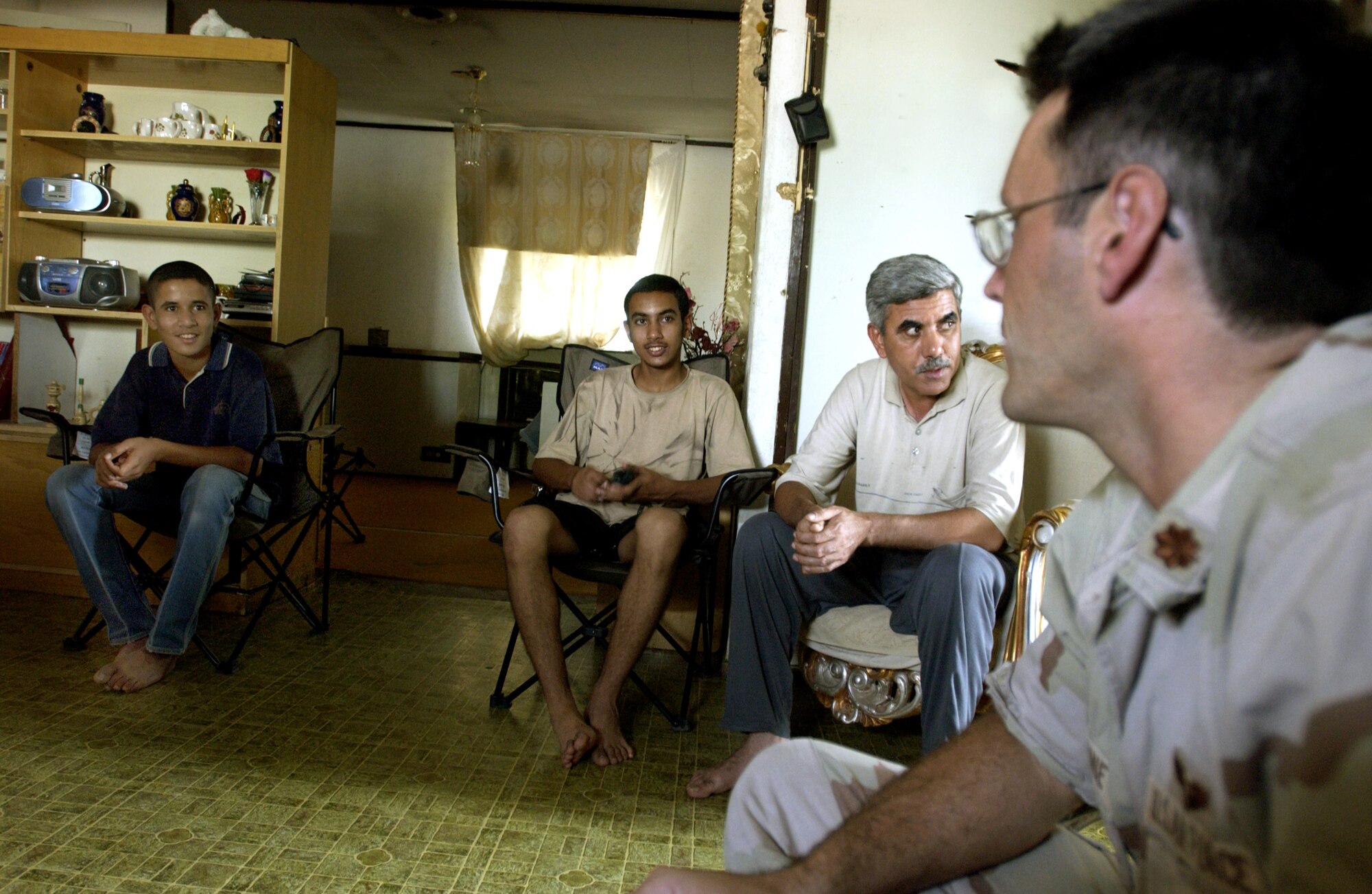 FRENCH VILLAGE, Iraq -- Maj. (Dr.) Gene Delaune gets a rare chance to visit in the home of an Iraqi family.  He was invited to have tea after treating villagers on the opening day of a not-for-profit clinic established here Oct. 18.  Delaune is an individual mobilization augmentee deployed from the 89th Medical Group at Andrews Air Force Base, Md.  (U.S. Air Force photo by Master Sgt. Keith Reed)