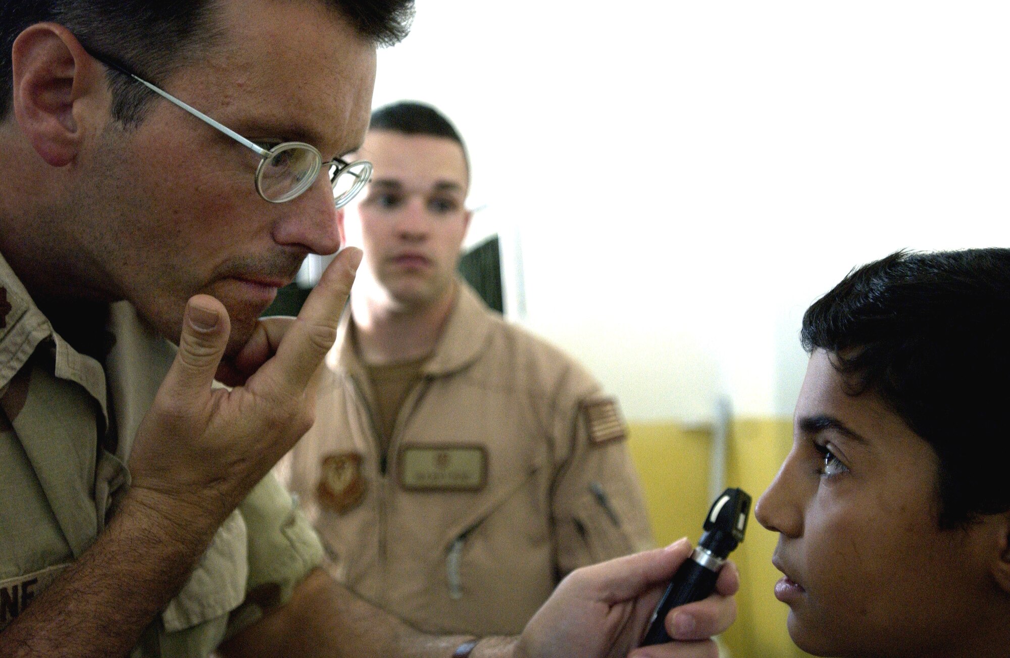 FRENCH VILLAGE, Iraq -- Maj. (Dr.) Gene Delaune examines a young Iraqi patient Oct. 18 in the new clinic here near Baghdad International Airport.  Delaune and several other American medical professionals volunteered to treat patients on the not-for-profit clinic's opening day.  Delaune is an individual mobilization augmentee deployed from the 89th Medical Group at Andrews Air Force Base, Md.  (U.S. Air Force photo by Master Sgt. Keith Reed)