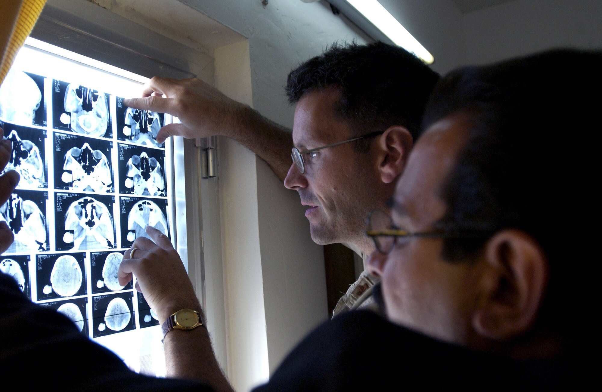 FRENCH VILLAGE, Iraq -- Maj. (Dr.) Gene Delaune and an Iraqi doctor look at the CT-scan images of a 12-year-old boy.  The doctors were trying to diagnose a vision problem.  On the clinic's first day, Oct. 18, it is neither fully staffed nor equipped, and only five patients were treated.  Delaune is an individual mobilization augmentee deployed from the 89th Medical Group at Andrews Air Force Base, Md.  (U.S. Air Force photo by Master Sgt. Keith Reed)