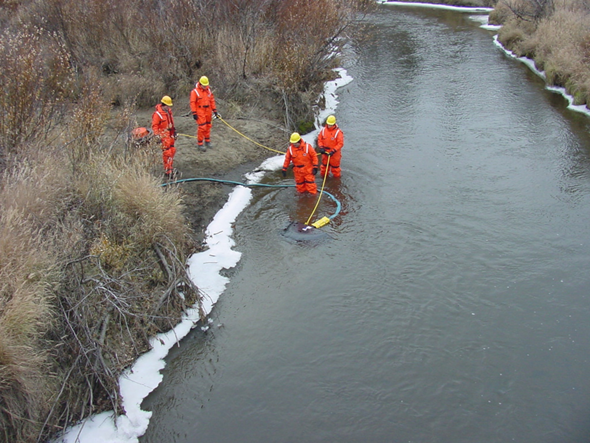 TATALINA, Alaska -- People from the 611th Civil Engineer Squadron spill team here deploy a manta ray skimmer during a fuel spill exercise on the Takotna River.  The simulated spill was part of an annual three-day event.  (U.S. Air Force photo by Senior Master Sgt. Robert Orrill)