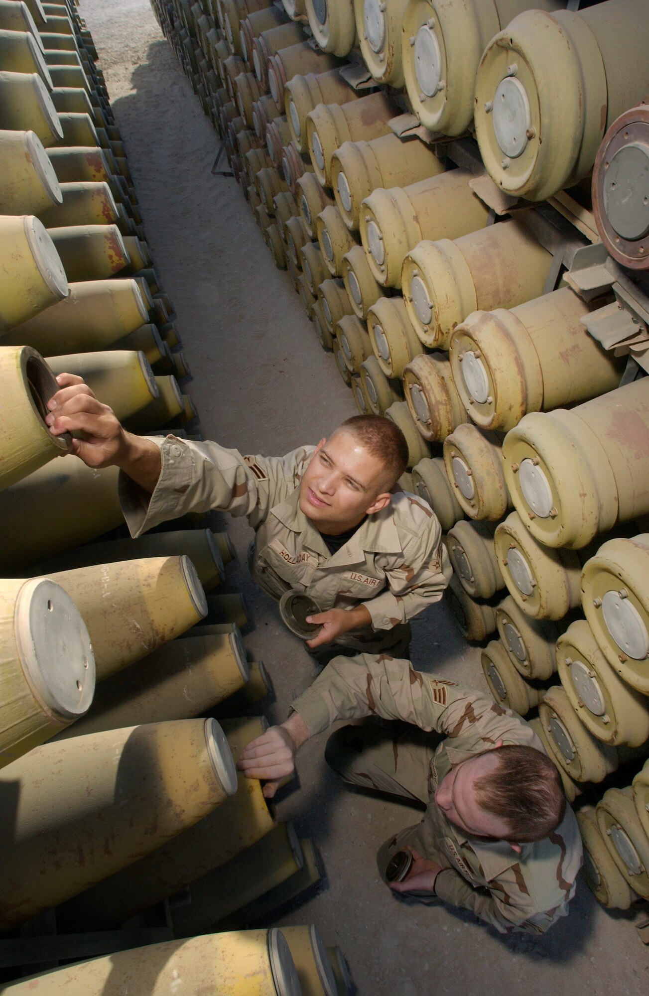 SOUTHWEST ASIA -- Airman 1st Class Jessie Holladay (left) and Senior Airman John Bronow inspect a MK-82 500-pound bomb in the munitions-storage area at an undisclosed location.  Both airmen are deployed from Royal Air Force Lakenheath, England, and recently volunteered to extend for an additional 30 days.  (U.S. Air Force photo by Master Sgt. Lance Cheung)
