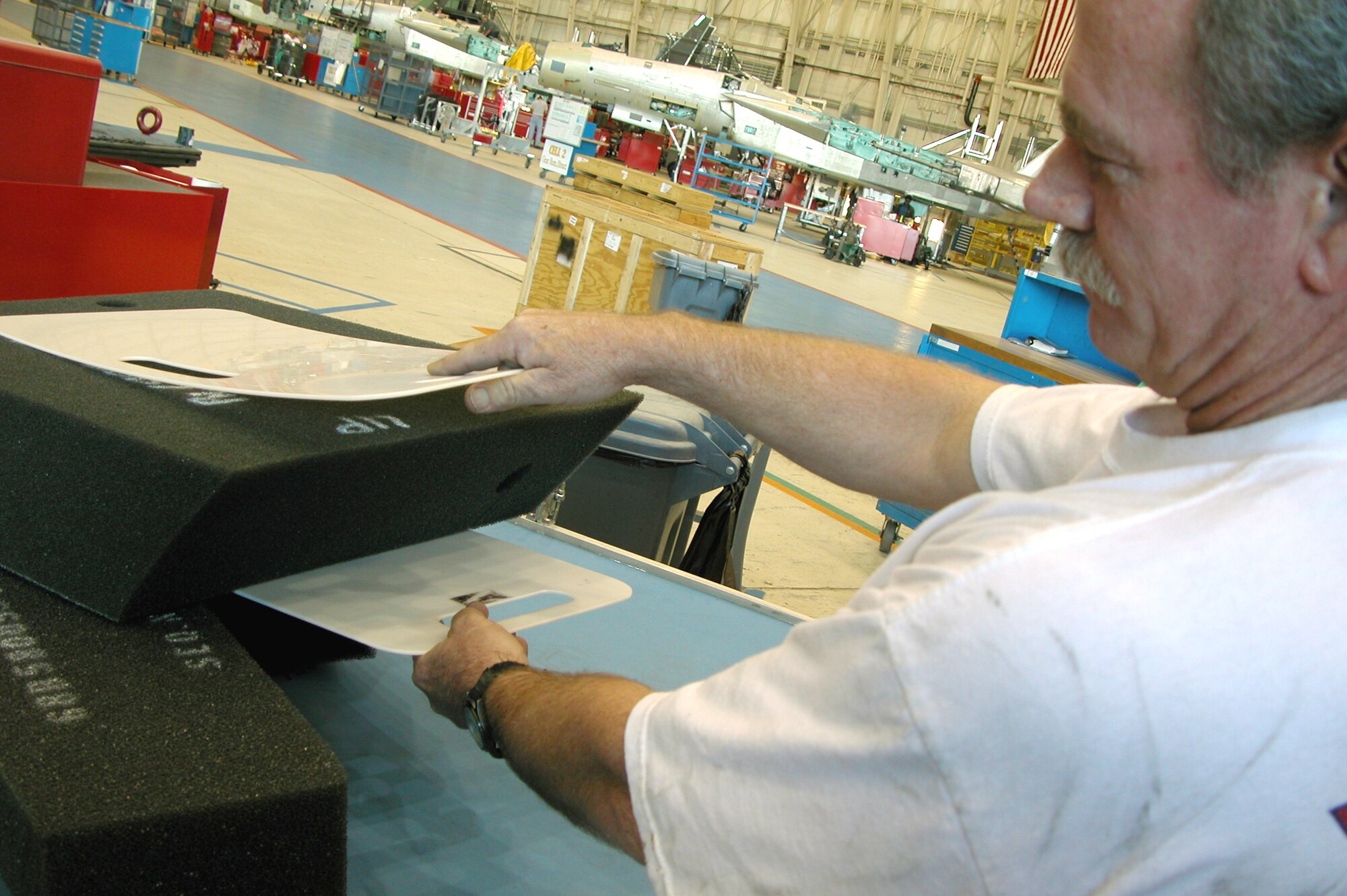 ROBINS AIR FORCE BASE, Ga. -- Steve Givens, an aircraft systems worker, demonstrates the use of Delrin Separators which allow foam sheets to be inserted into F-15 Eagle fuel tanks easier than workers placing them in manually.  The separator is one of three new intervention tools that has produced reductions in ergonomic risks.  (U.S. Air Force photo by Sue Sapp)