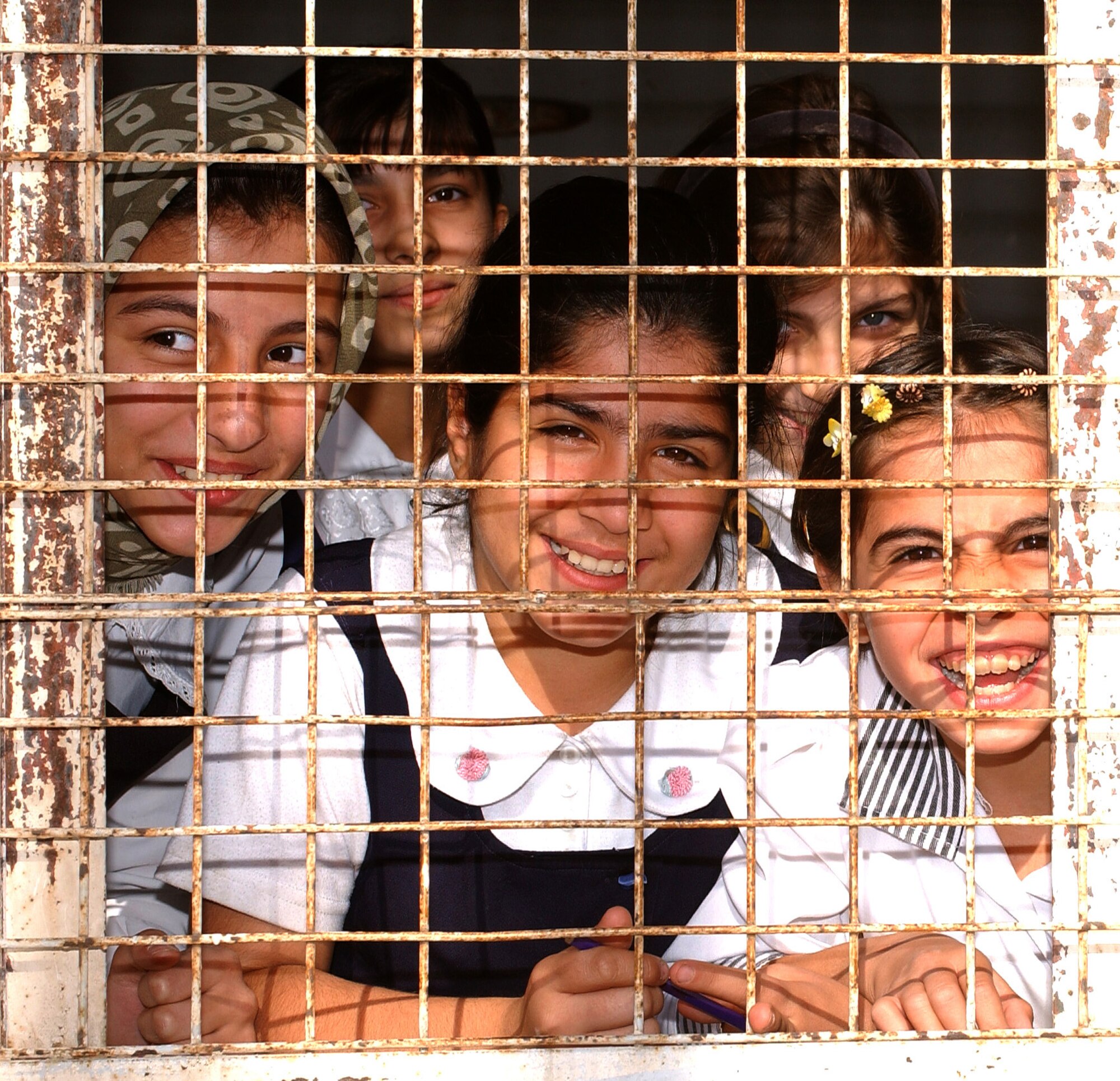 KIRKUK, Iraq -- Children at Al Ilaf school here greet airmen arriving with educational supplies.  The $5,000 in supplies came from voluntary donations of 380th Air Expeditionary Wing airmen at a forward-deployed air base.  (U.S. Air Force photo by Staff Sgt. James A. Williams)