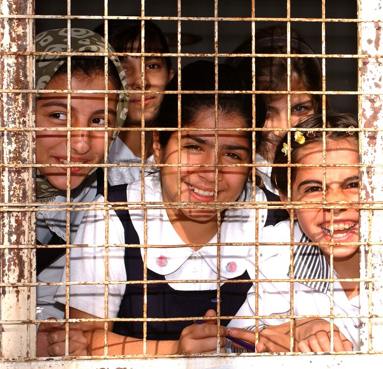 KIRKUK, Iraq -- Children at Al Ilaf school here greet airmen arriving with educational supplies.  The $5,000 in supplies came from voluntary donations of 380th Air Expeditionary Wing airmen at a forward-deployed air base.  (U.S. Air Force photo by Staff Sgt. James A. Williams)