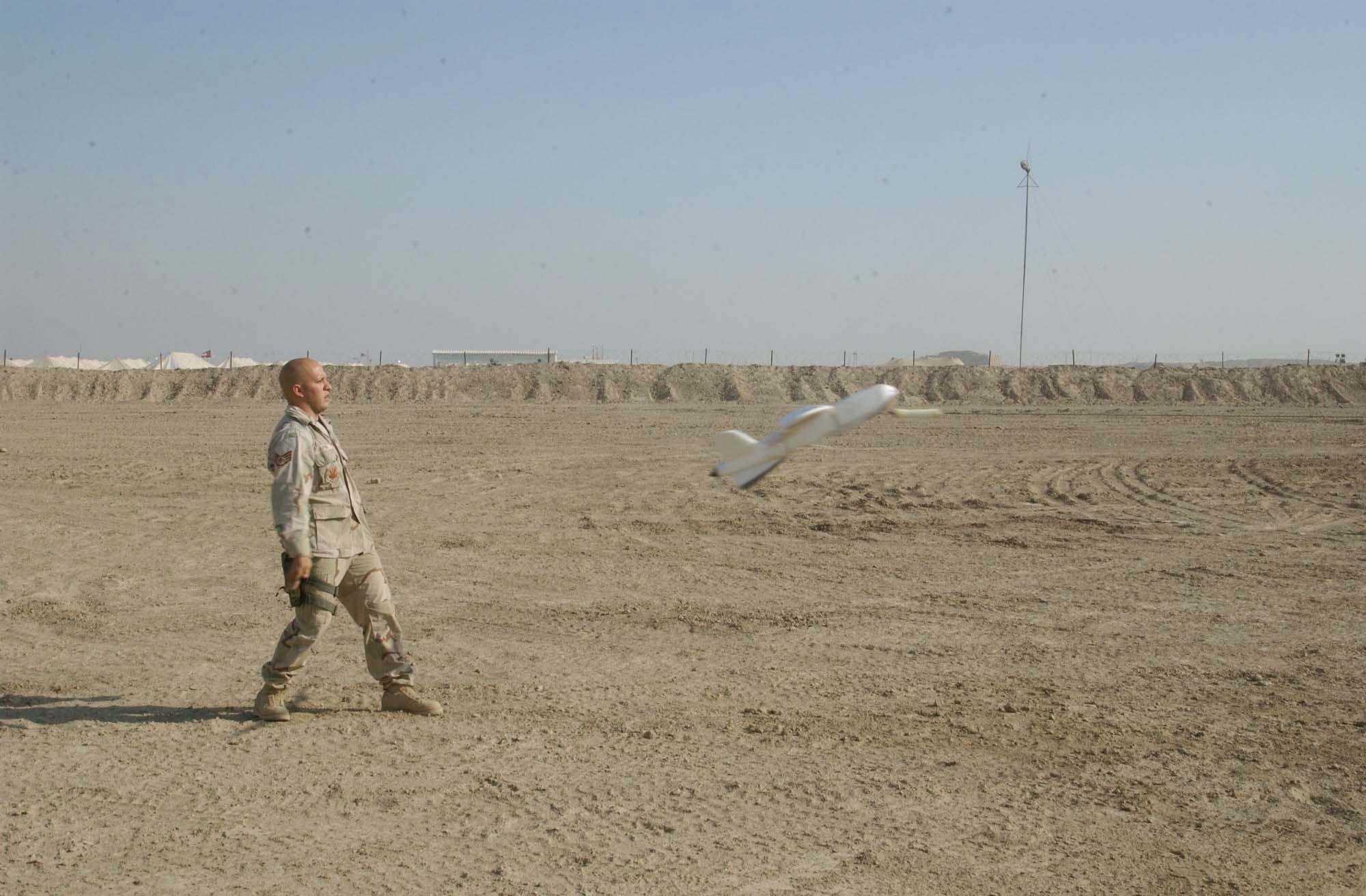 TALLIL AIR BASE, Iraq -- Staff Sgt. Joseph Vialpando recoils after releasing the Desert Hawk aircraft.  The 4-foot-long plane uses a bungee cord catapult system to provide acceleration for takeoff.  Vialpondo is part of the 332nd Expeditionary Security Forces Squadron.  (U.S. Air Force photo by Master Sgt. Don Perrien)